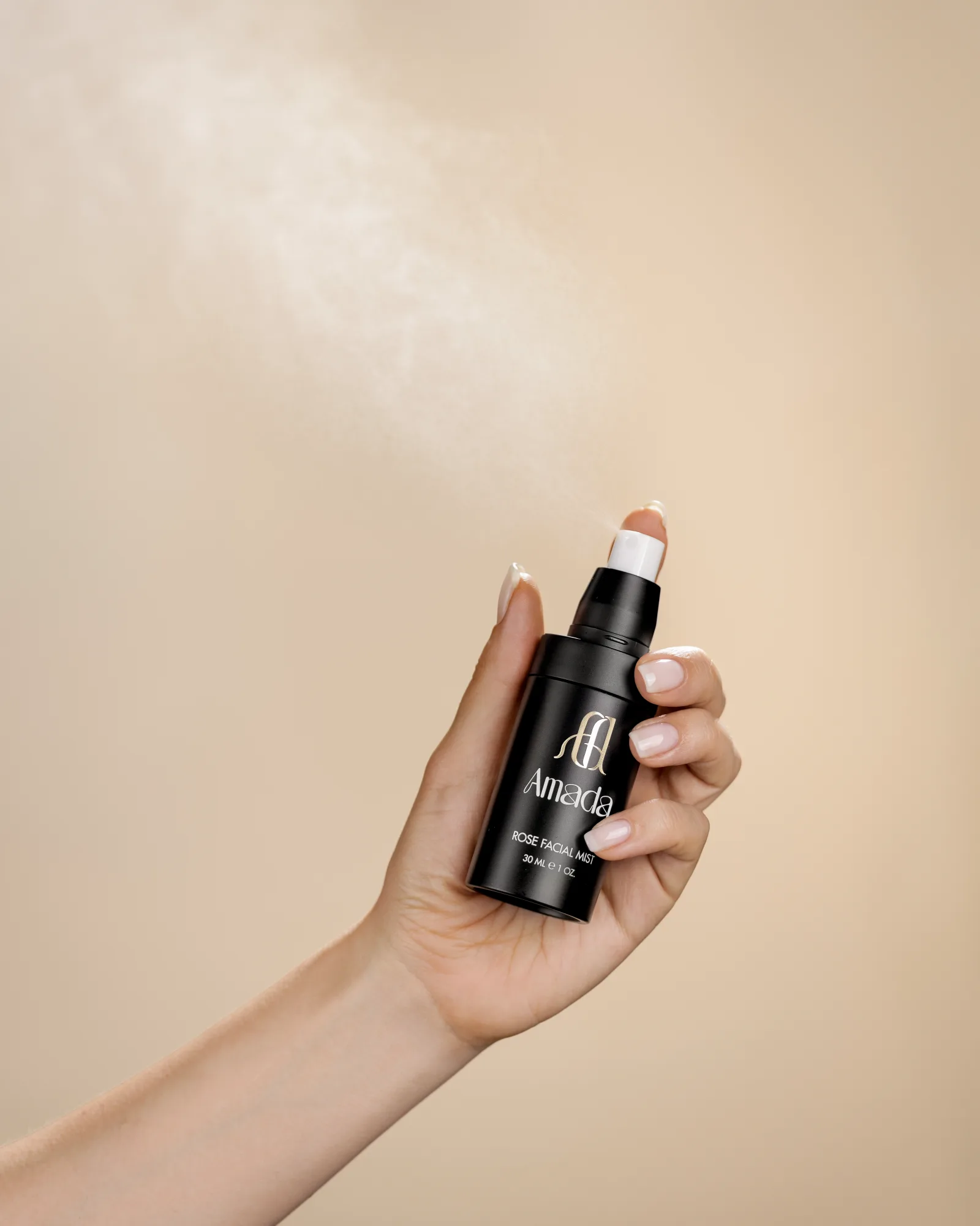 Rose Facial Mist AMADA в ръка с фин облак спрей, реален студиен кадър