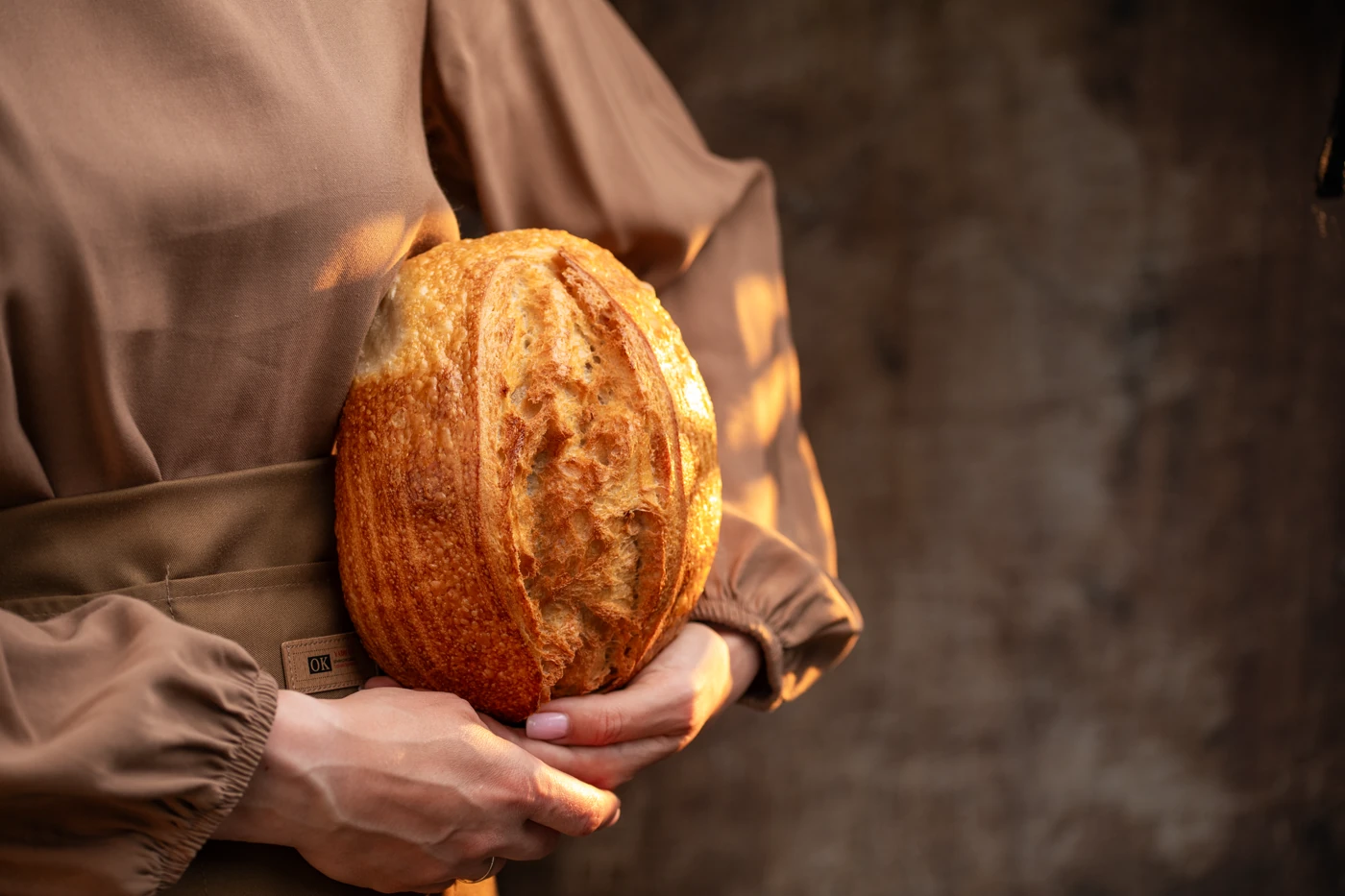 Holding the loaf - warm side-light on golden crust