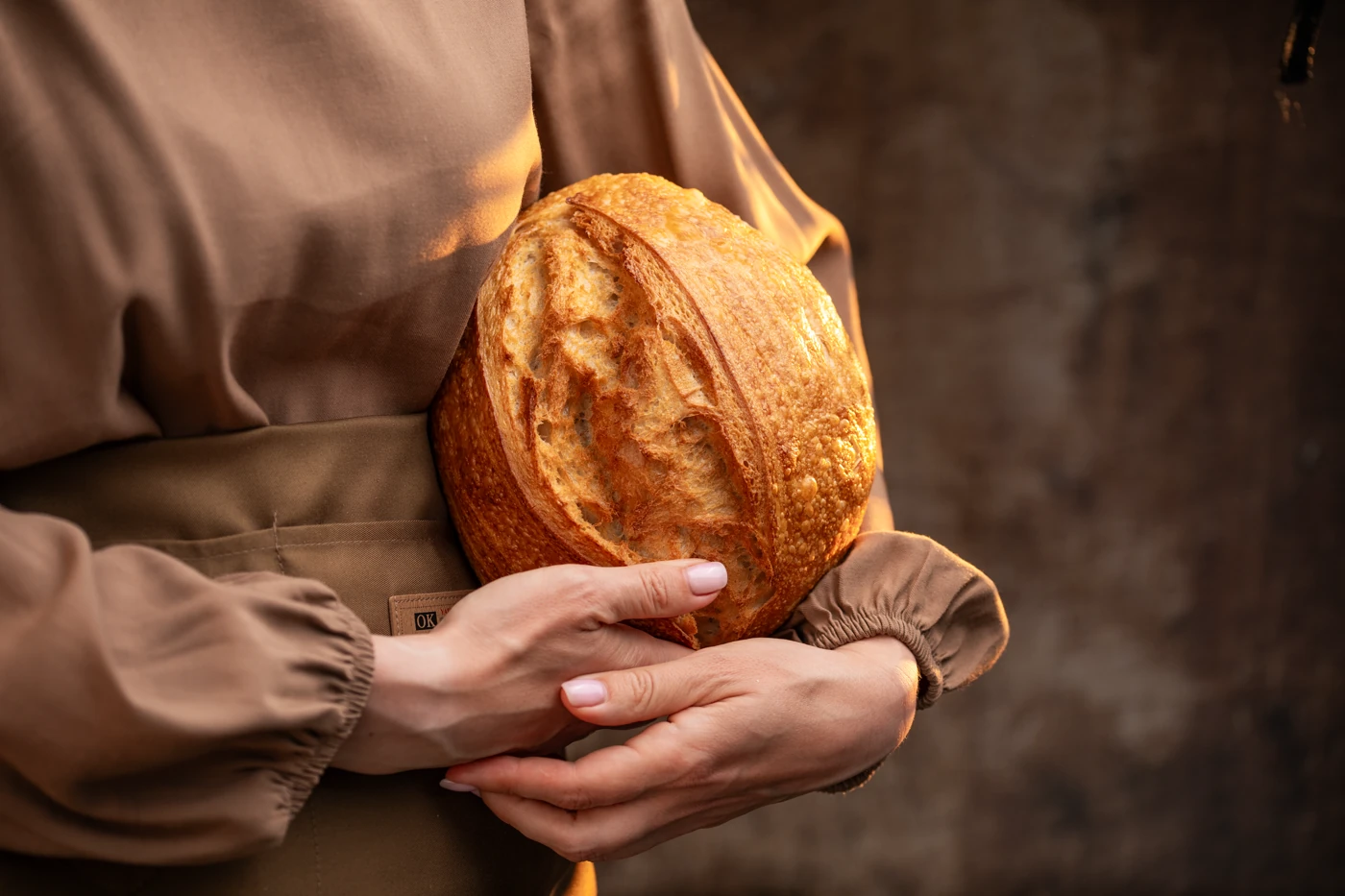 Hands cradling artisan sourdough - warm, golden, intimate