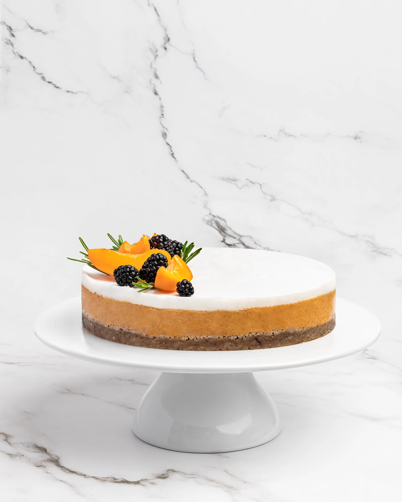 Apricot blackberry cake on stand with rosemary - seasonal presentation