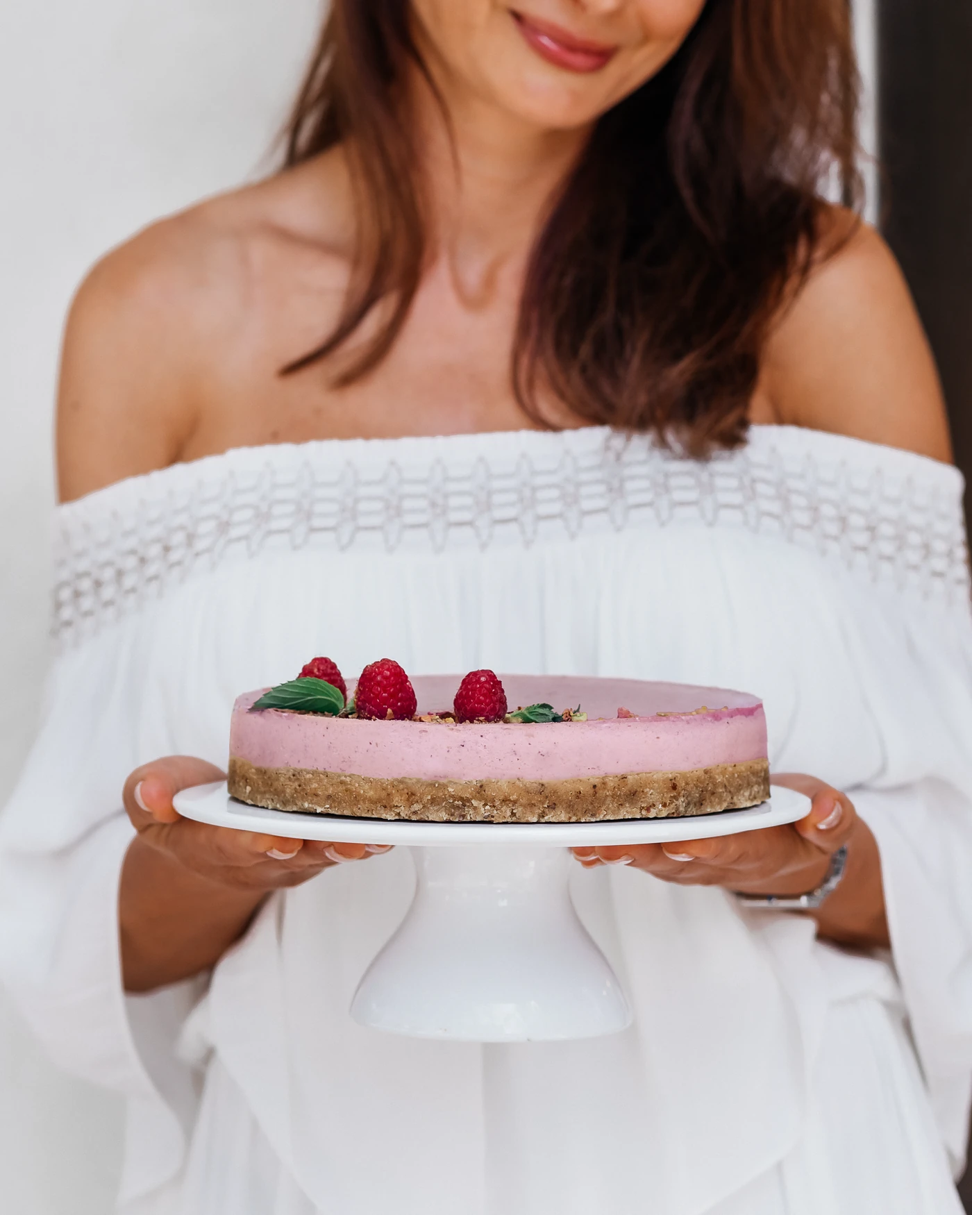 Lifestyle - whole cake being presented by hand