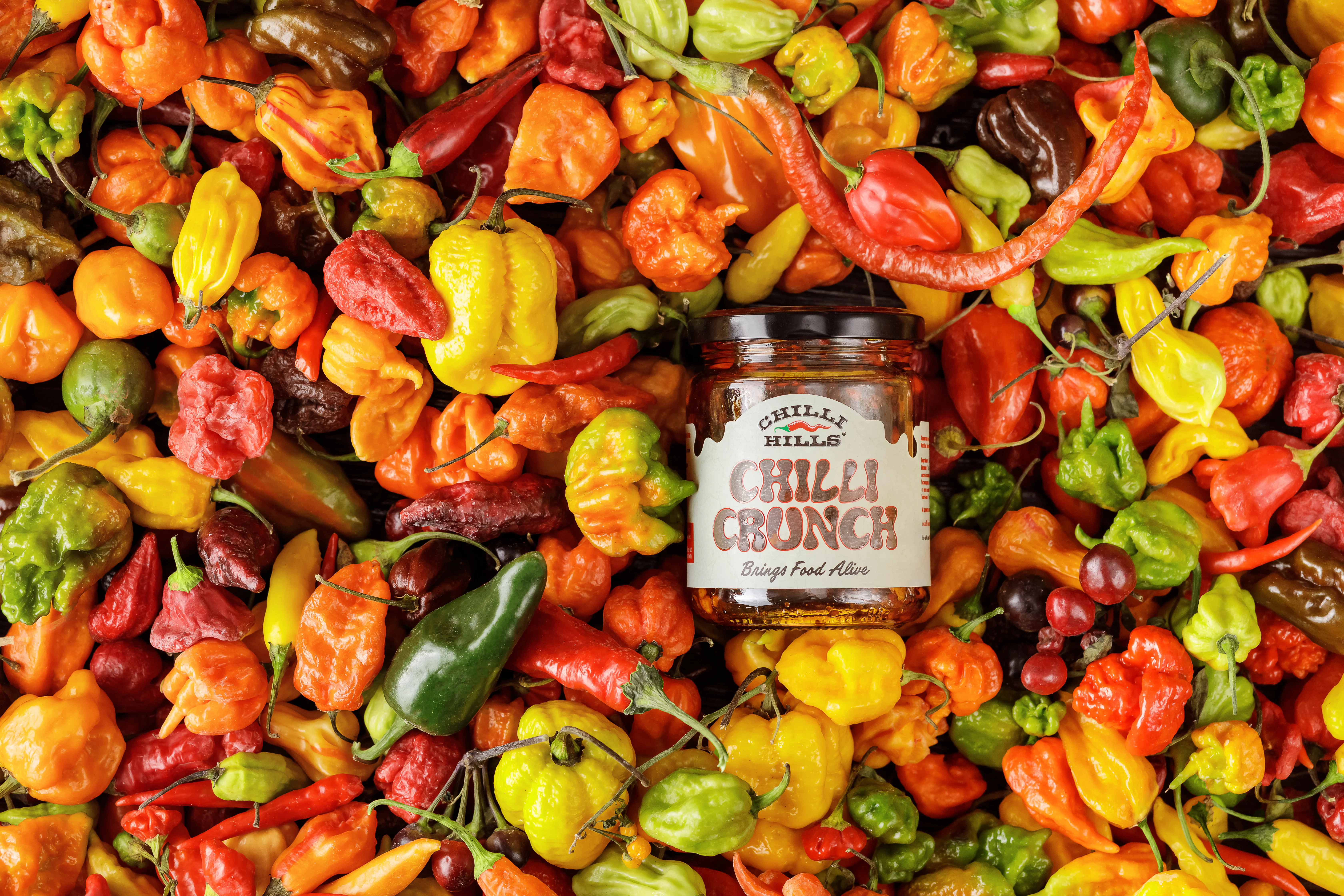 Chilli Hills Chilli Crunch - lifestyle context with fresh peppers