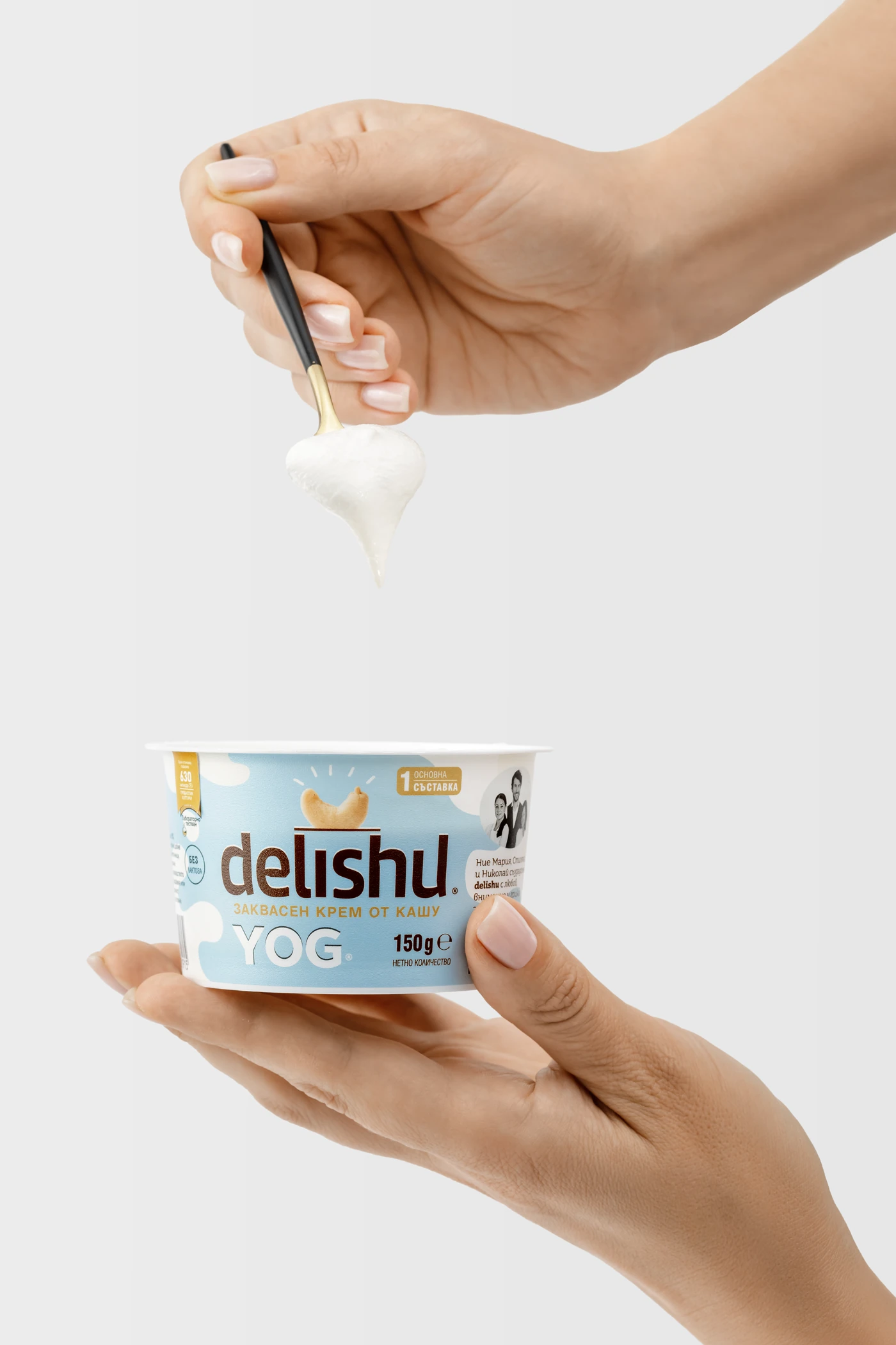 Ръце, които държат Delishu, докато лъжица повдига текстурата