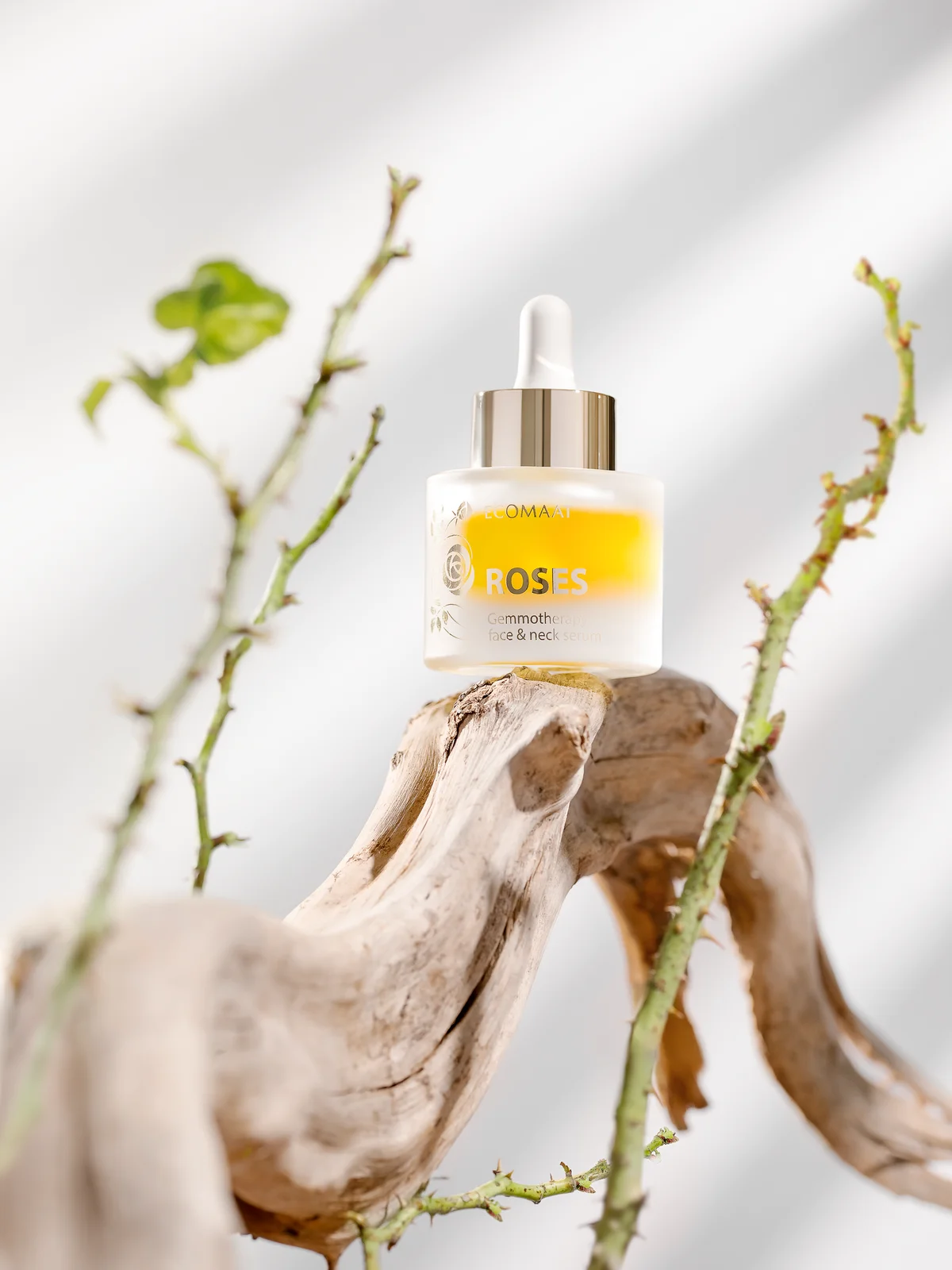 ECOMAAT Roses serum on driftwood with golden tones
