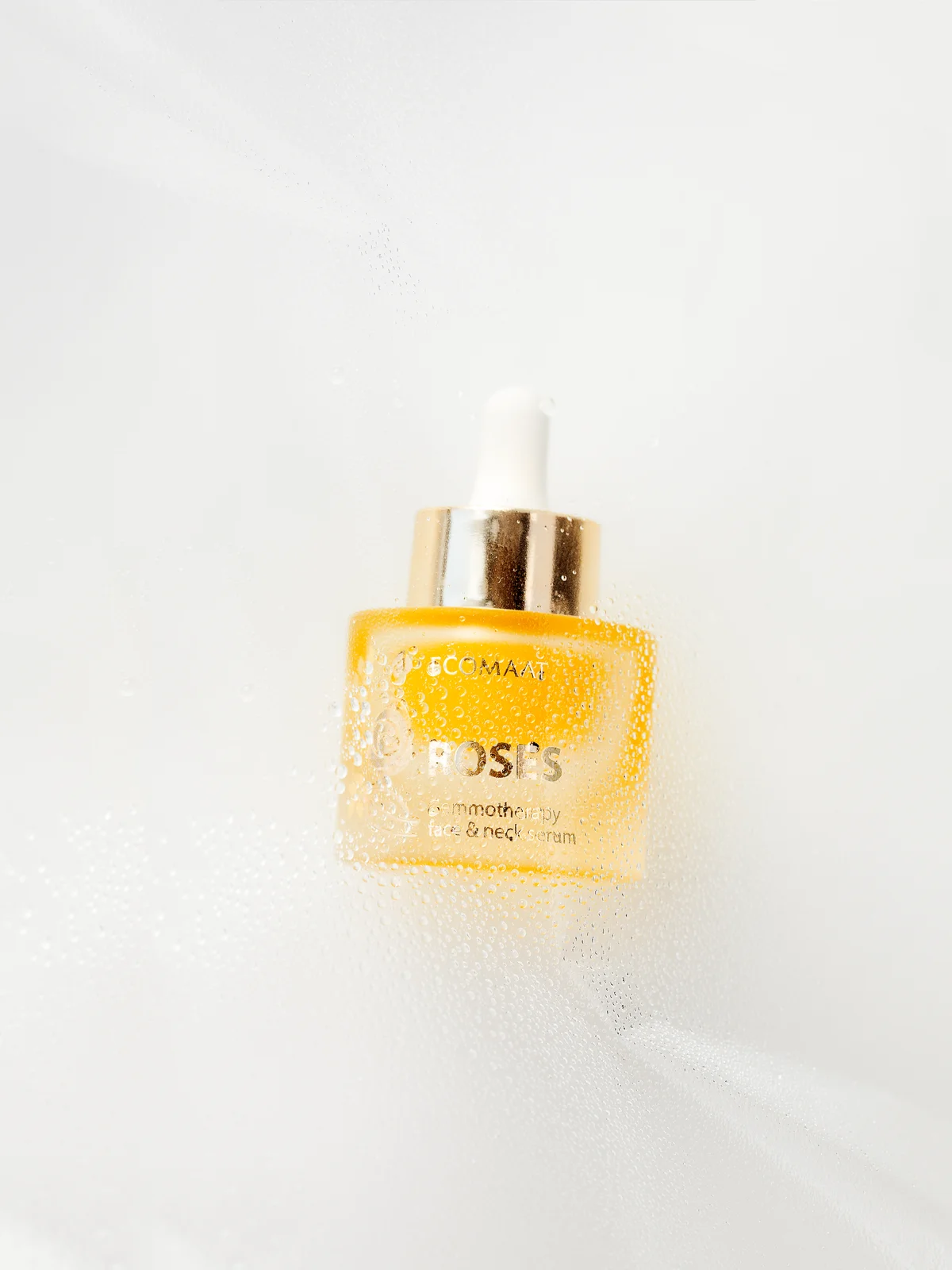 ECOMAAT serum captured in foam with golden tones and water mist