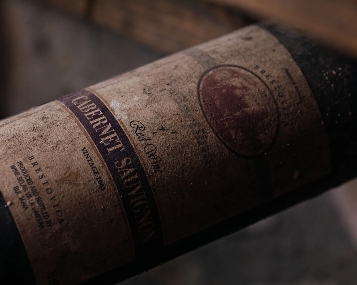 Бутилка българско вино Dusty Villa Vinifera Каберне Совиньон 2003, отразяваща историята на избата.