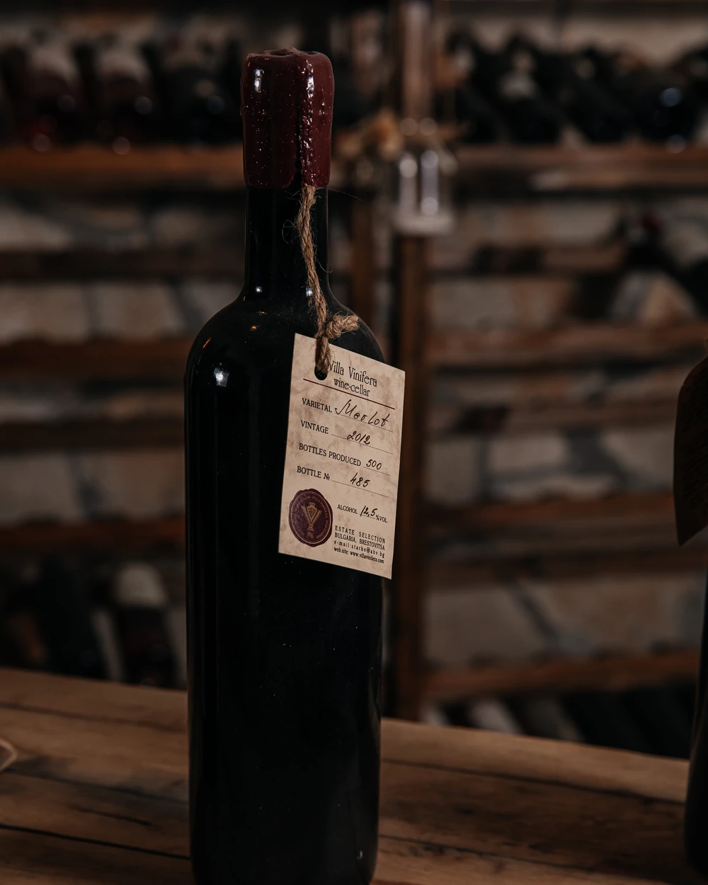 Бутилка българско вино Villa Vinifera Merlot 2012 от пловдивска изба, с восъчен печат и винтидж етикет.