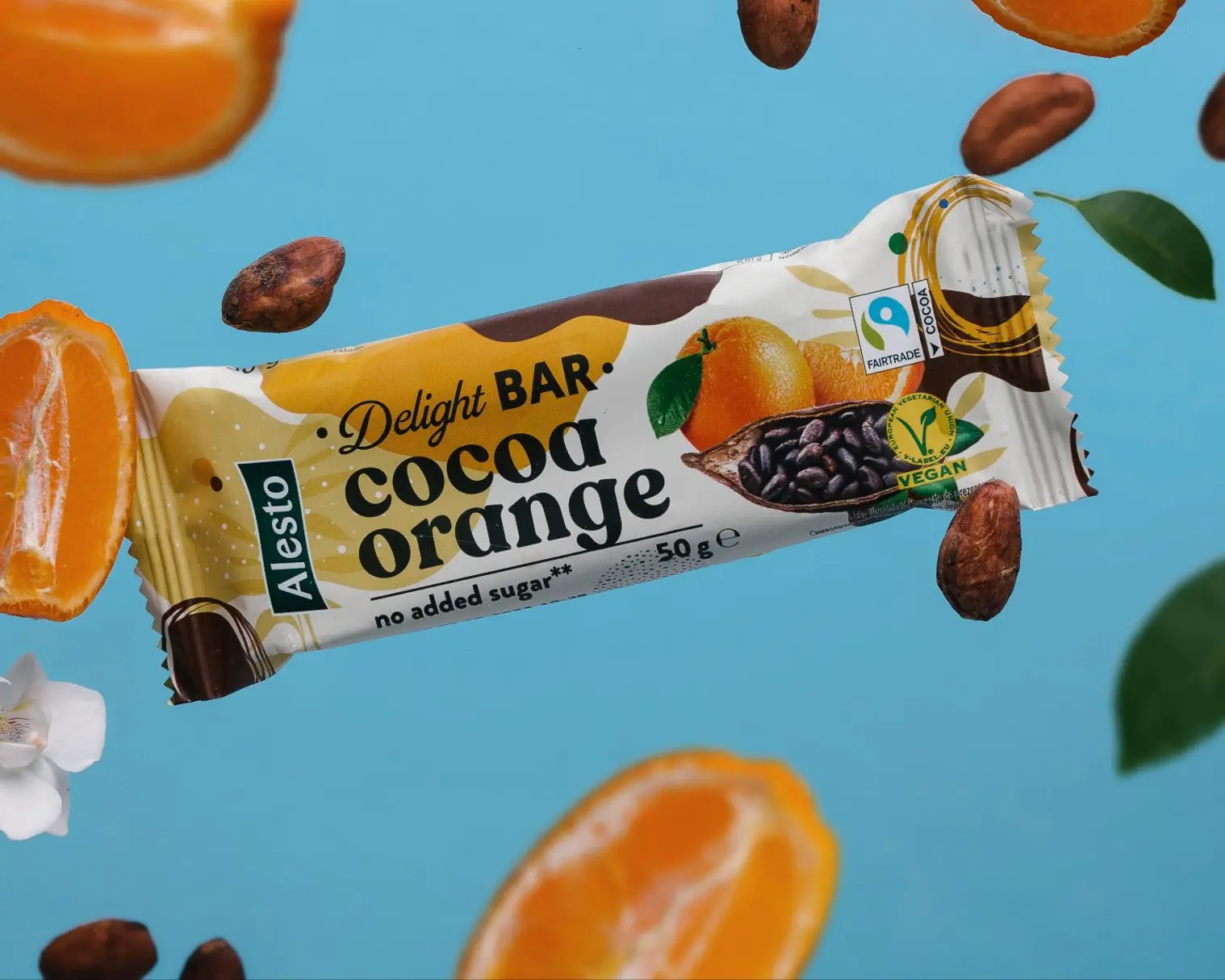 Alesto Delight BAR Cocoa Orange (vegan, no added sugar) floats with oranges, cocoa beans on blue for product photography.