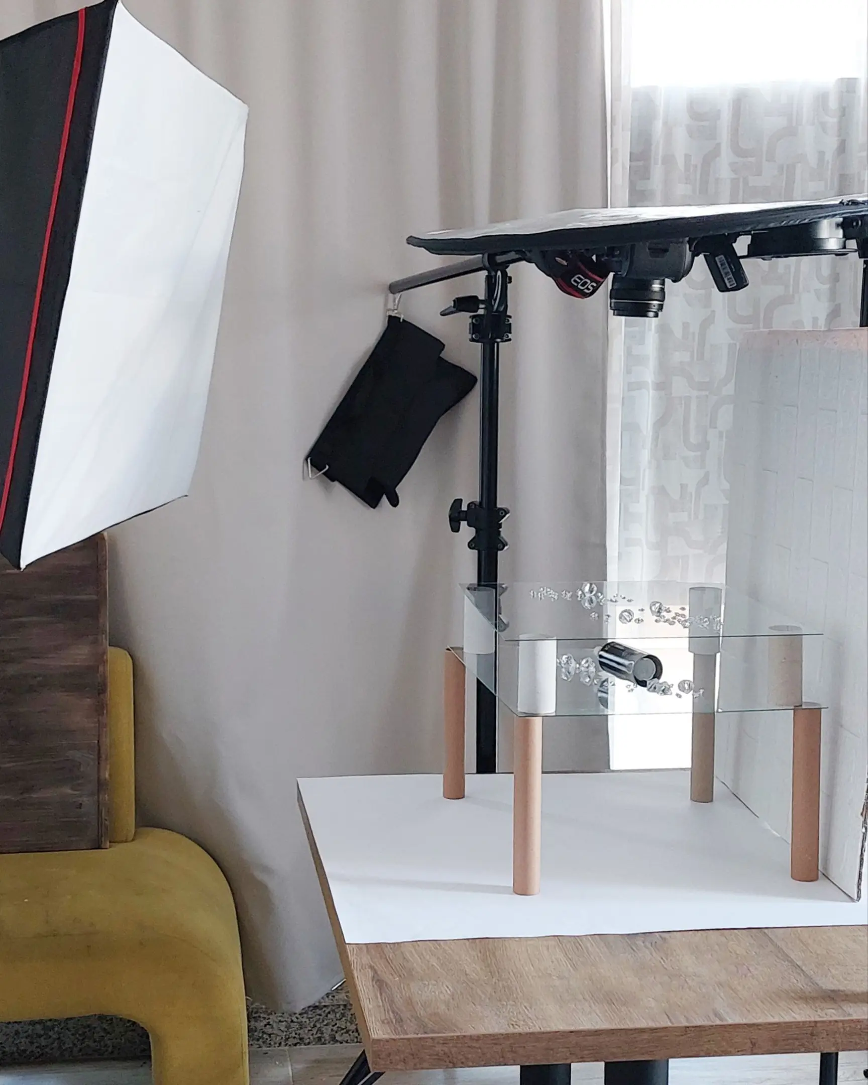 Studio setup for product photography showing Canon EOS camera, softbox, and glass photo frames for floating effects.