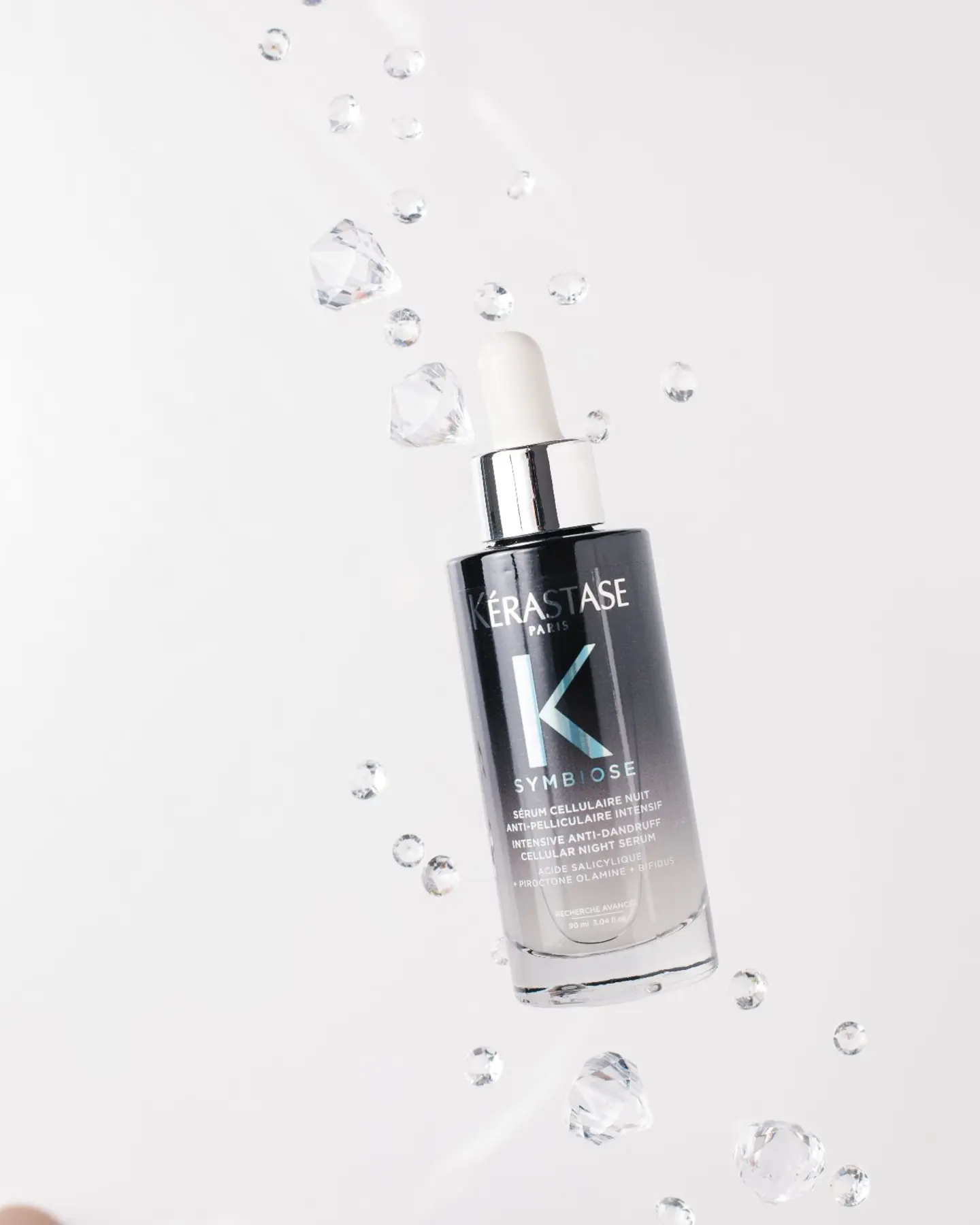 KÉRASTASE SYMBIOTIC Cellular Night Serum floats with suspended droplets for a "wow" product photography effect.