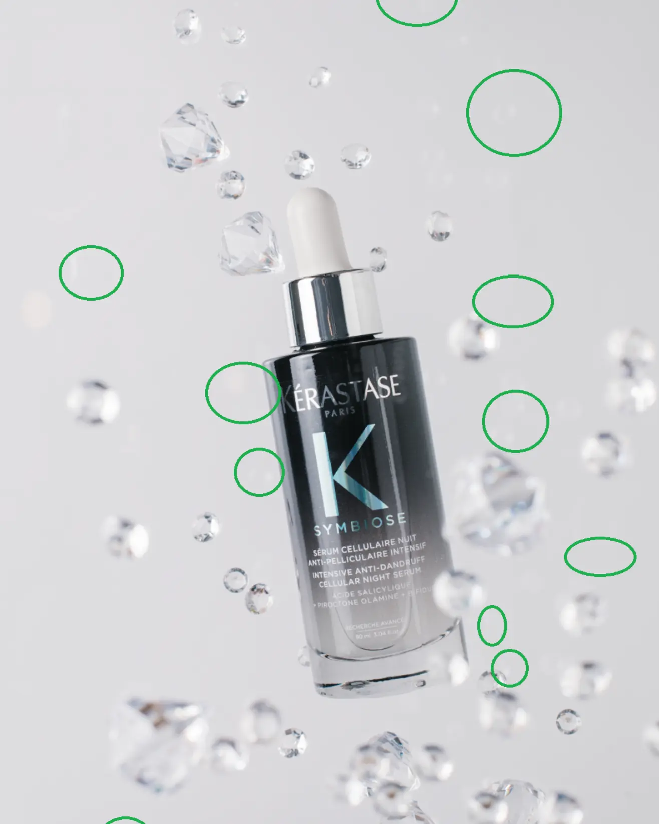 Kérastase Symbiose Anti-Dandruff Serum bottle with suspended droplets, product photography using glass.