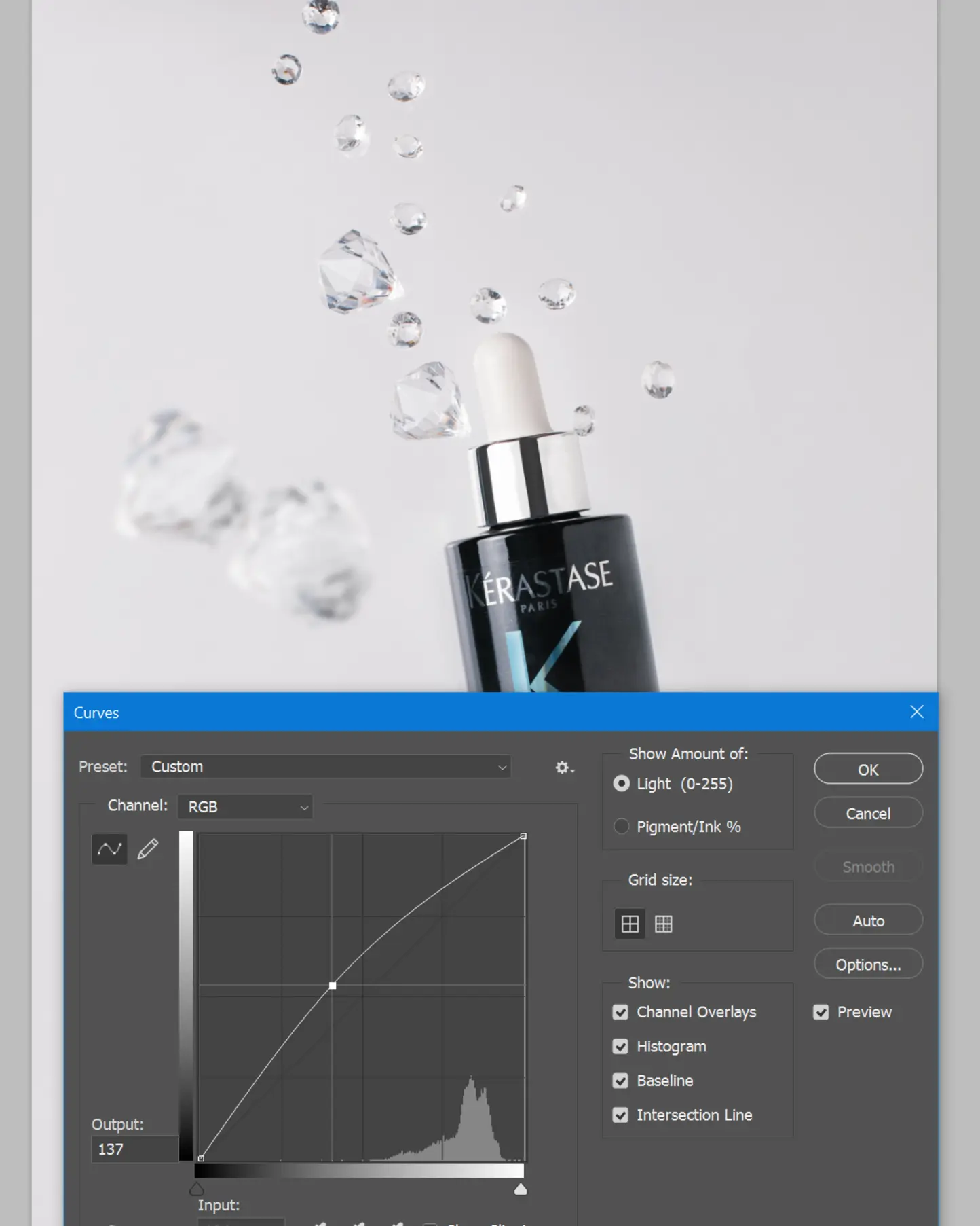 KÉRASTASE PARIS serum bottle with floating clear gems, showcasing suspended droplet effect for product photography.