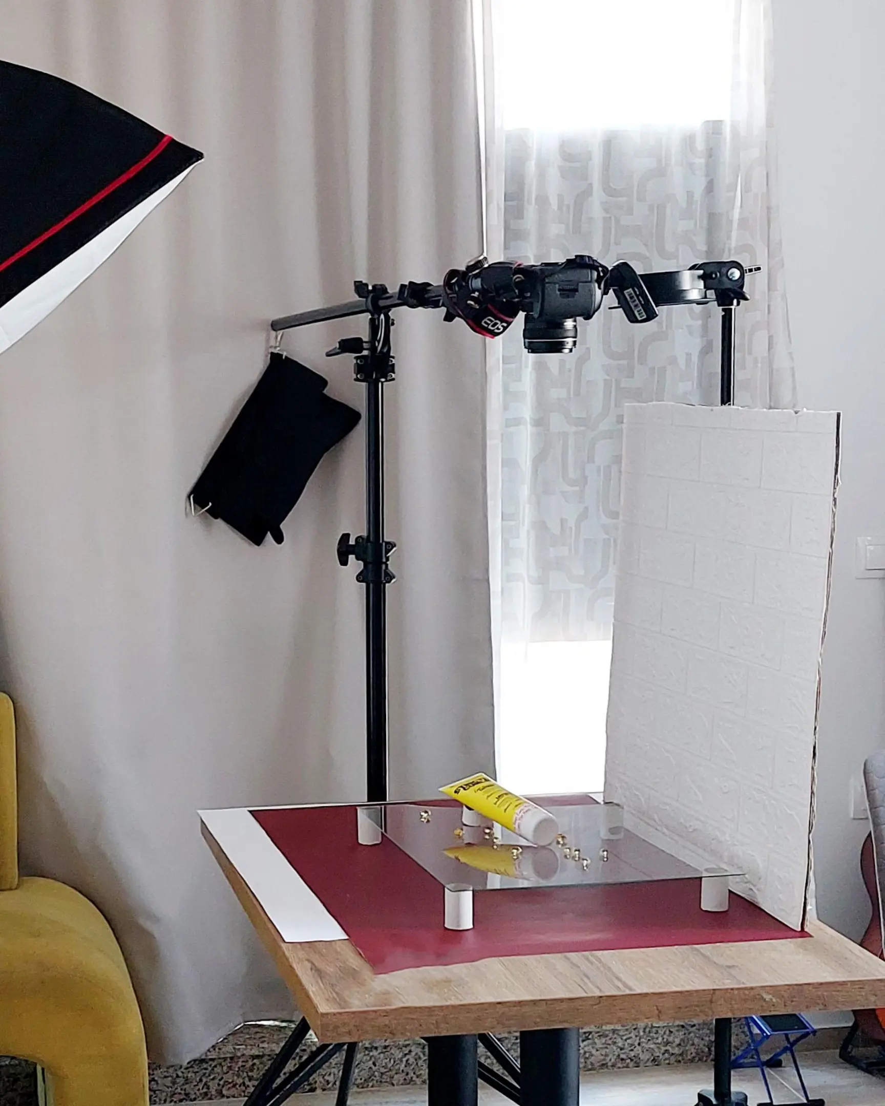 Product photography studio setup with Canon EOS camera and glass frame, showcasing a yellow tube & beads floating.
