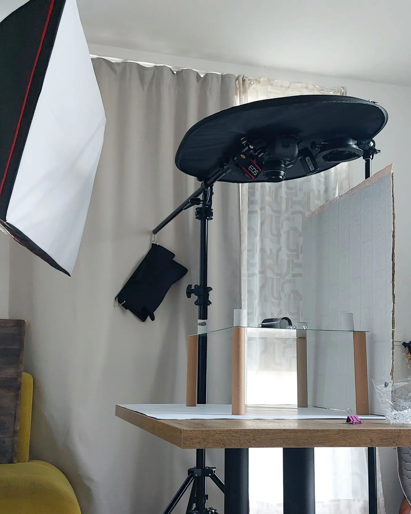 Product photography studio setup with Canon EOS camera, softbox, and glass for floating effects.