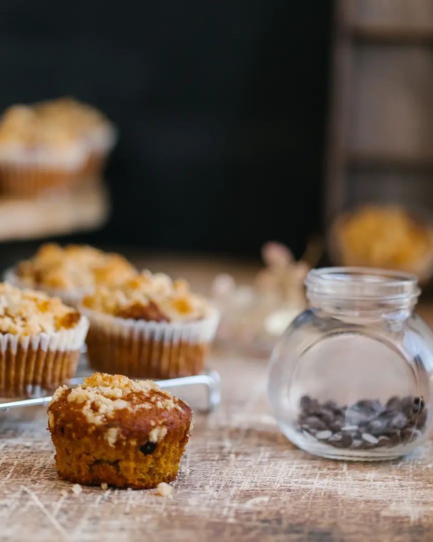 Homemade pumpkin muffins with sweet crumble topping & chocolate chips, perfect for fall baking.