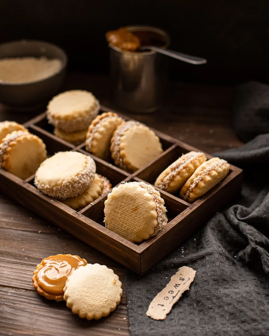 Слепени бисквитки с варено кондензирано мляко и кокосови стърготини, в дървена кутия с кен карамел и кокос.