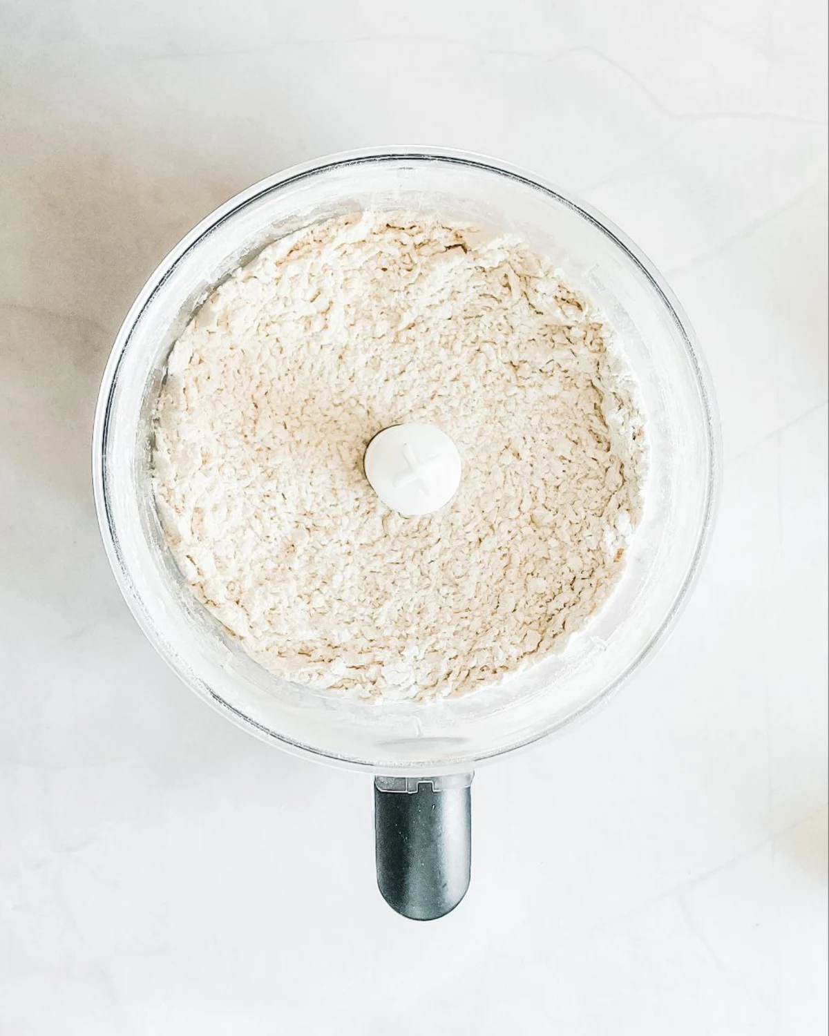 Брашно и студено масло, смесени на сухи трохи в робот за домашни тиквени скони.