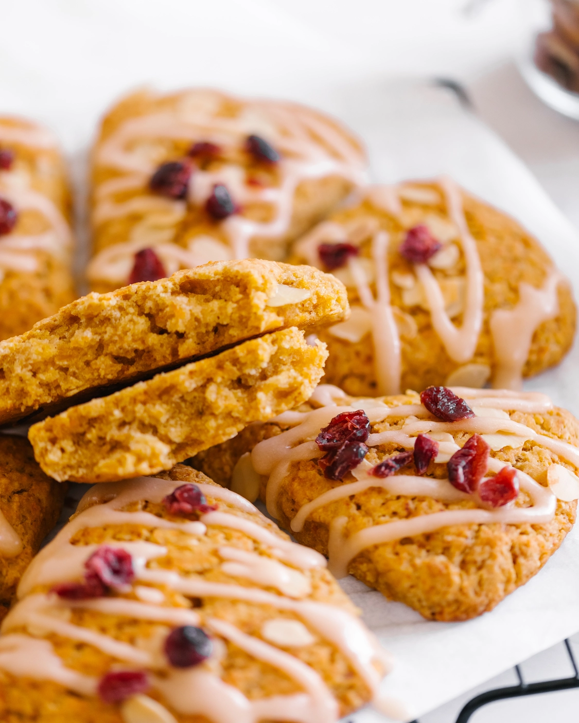 Вкусни тиквени скони с глазура, сушени червени боровинки и бадеми, идеални за хладна есенна сутрин.