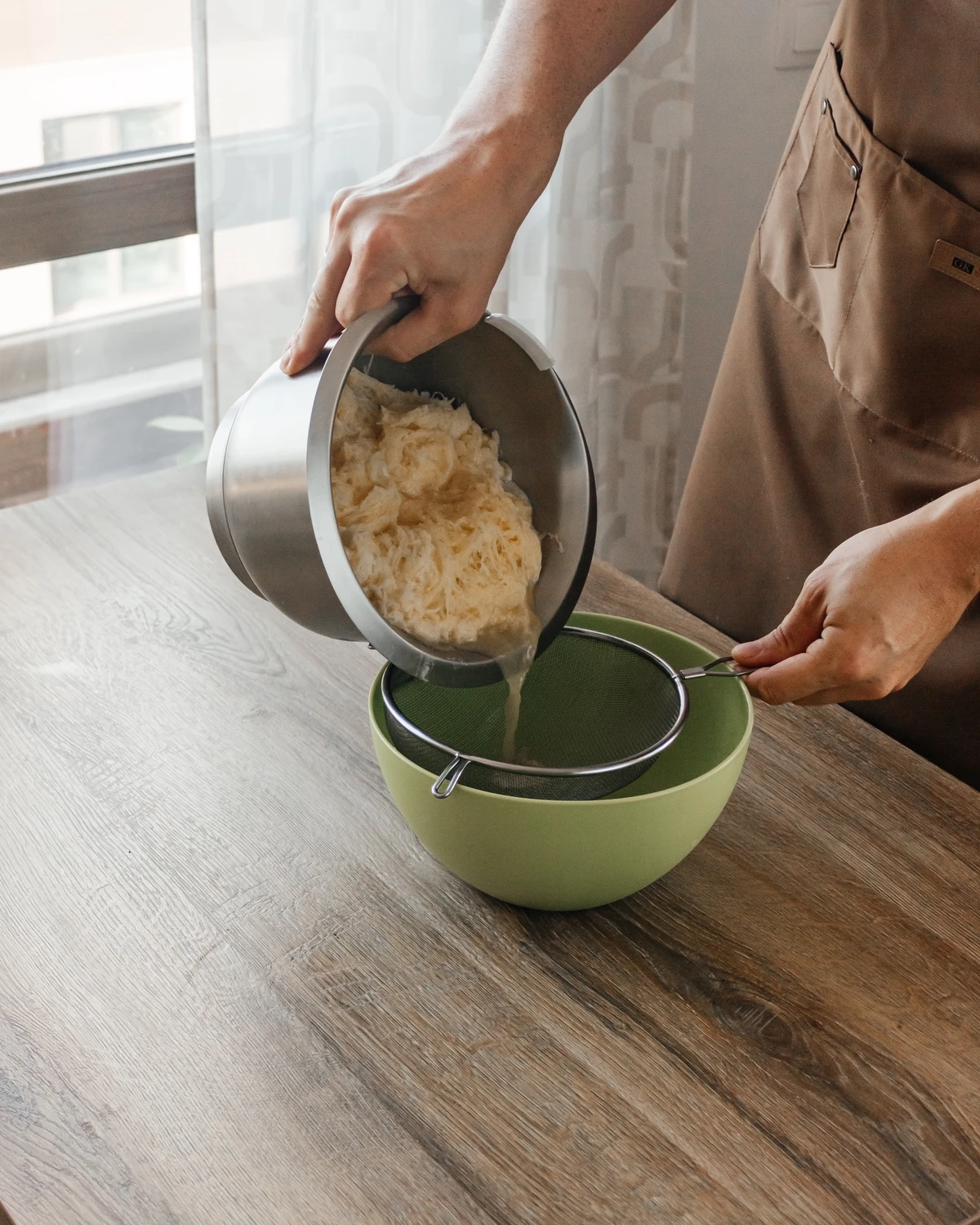 Grated raw potatoes being strained for potato babka, a classic Belarusian, Lithuanian & Jewish dish.