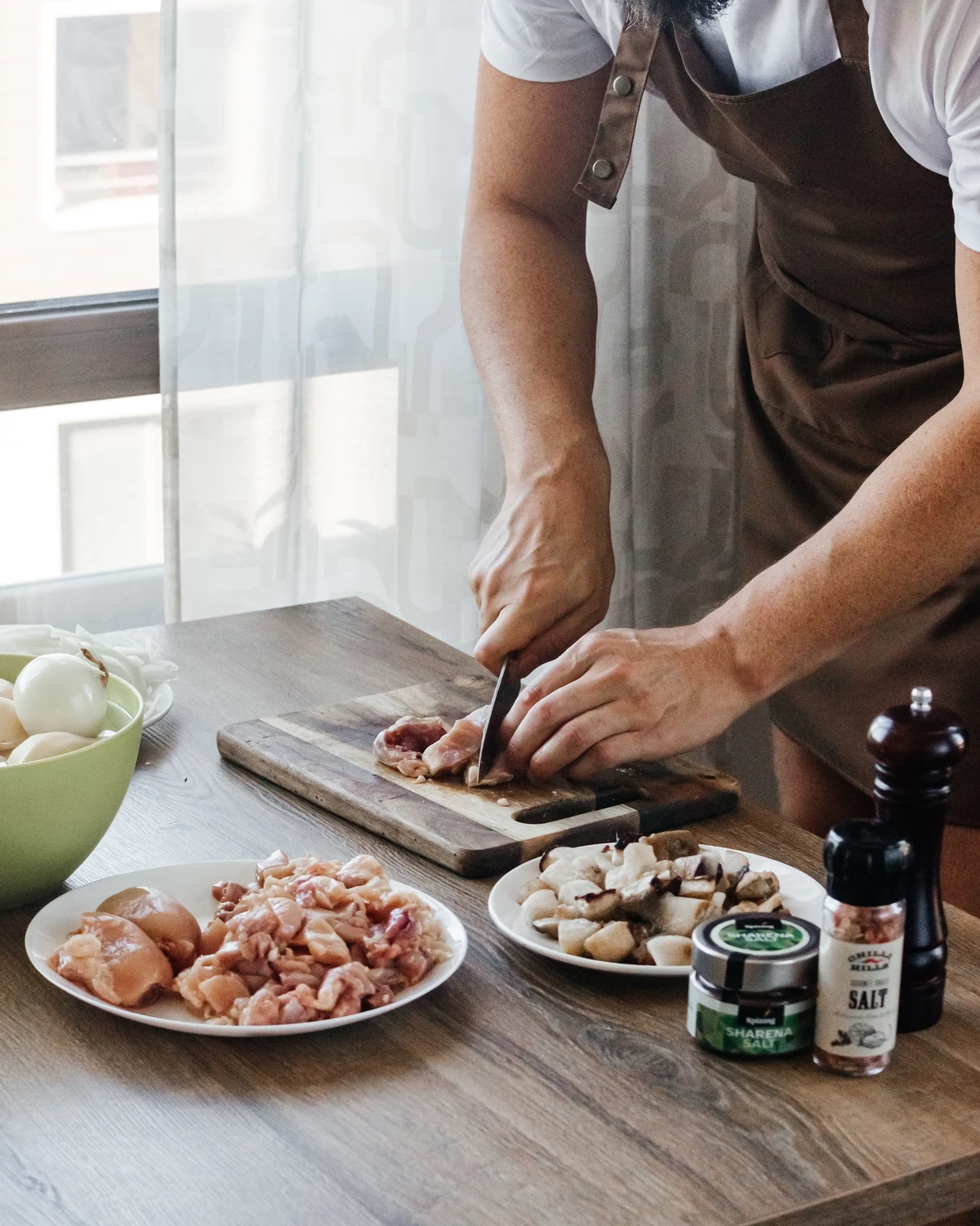 Chef slicing chicken & Royal mushrooms for traditional Belarusian Kugel with onions, salt, and spices.
