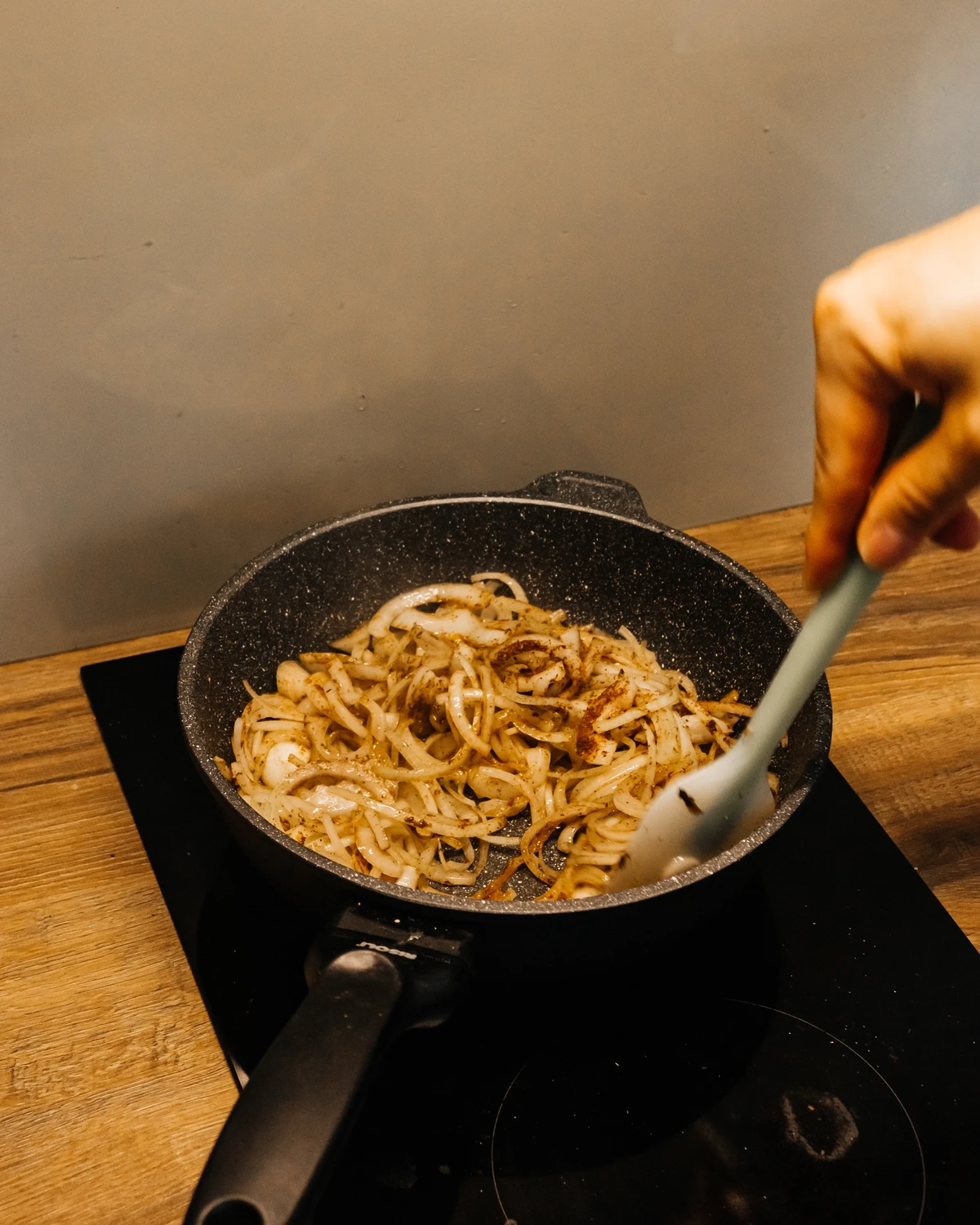 Frying golden onions in a pan for the Bulbyanaya grandmother (Kugel) potato casserole recipe.