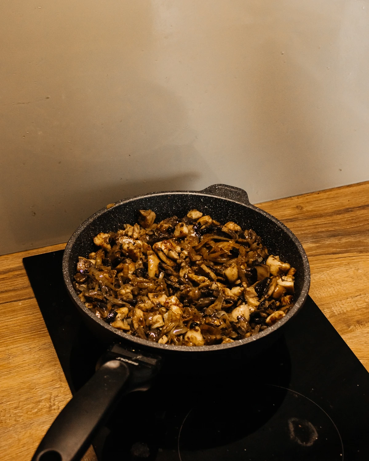 Fried mushrooms, onions, and chicken in a pan, preparing the delicious filling for traditional potato babka Kugelis.