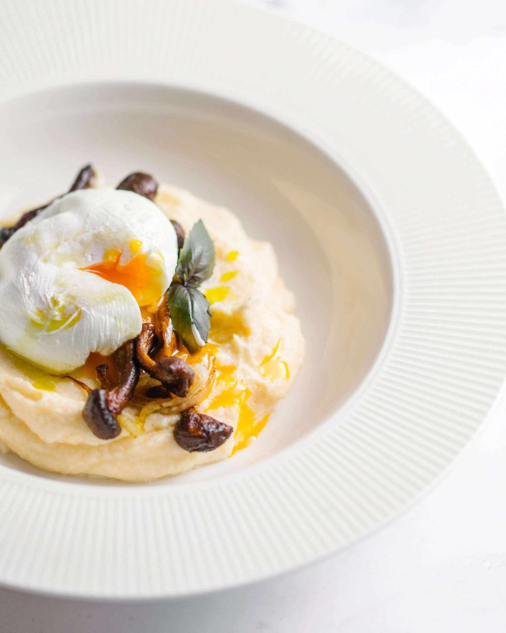 Карфиолено пюре с пържени пънчета, поширано яйце, трюфелово масло и пресни билки.