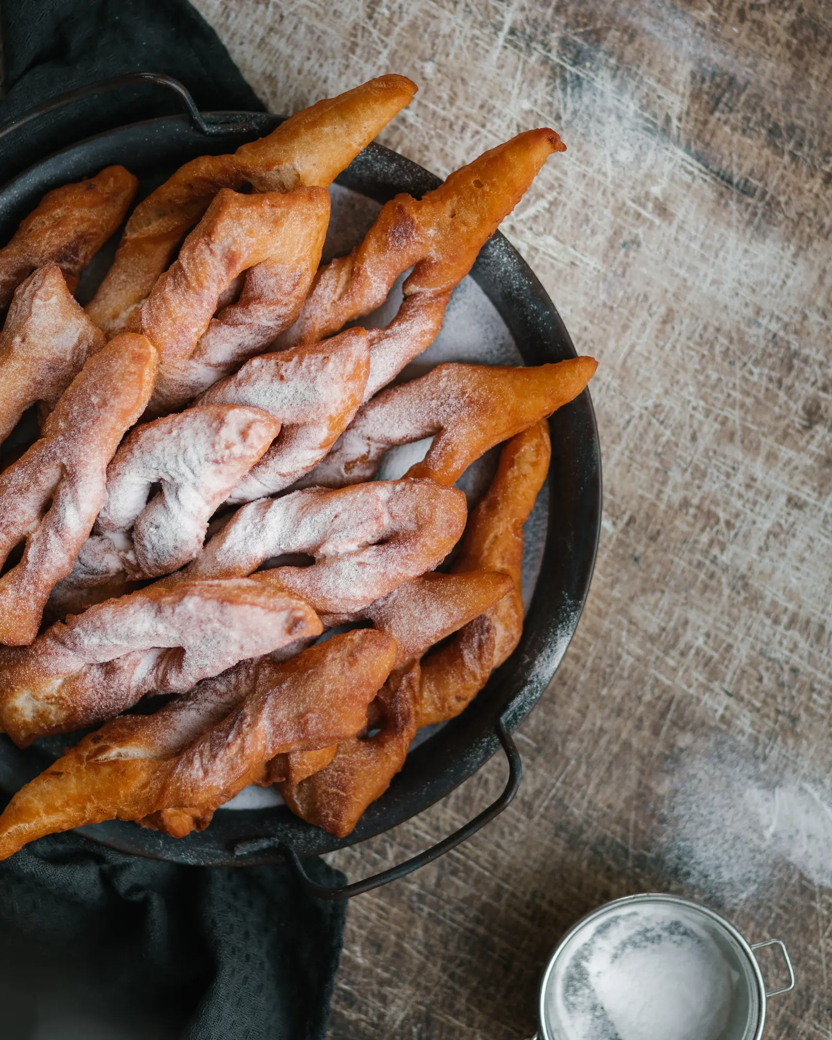 Plate of golden-brown fried Hvorost dessert, light & fluffy, dusted with powdered sugar for a sweet treat.