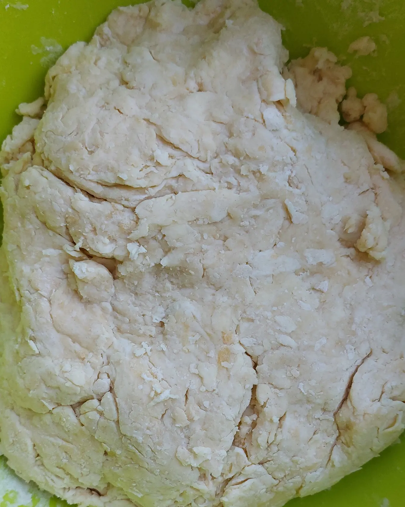 Омесено, леко нехомогенно слоесто тесто в зелена купа, показващо правилната текстура за рецепта за сладкиш.