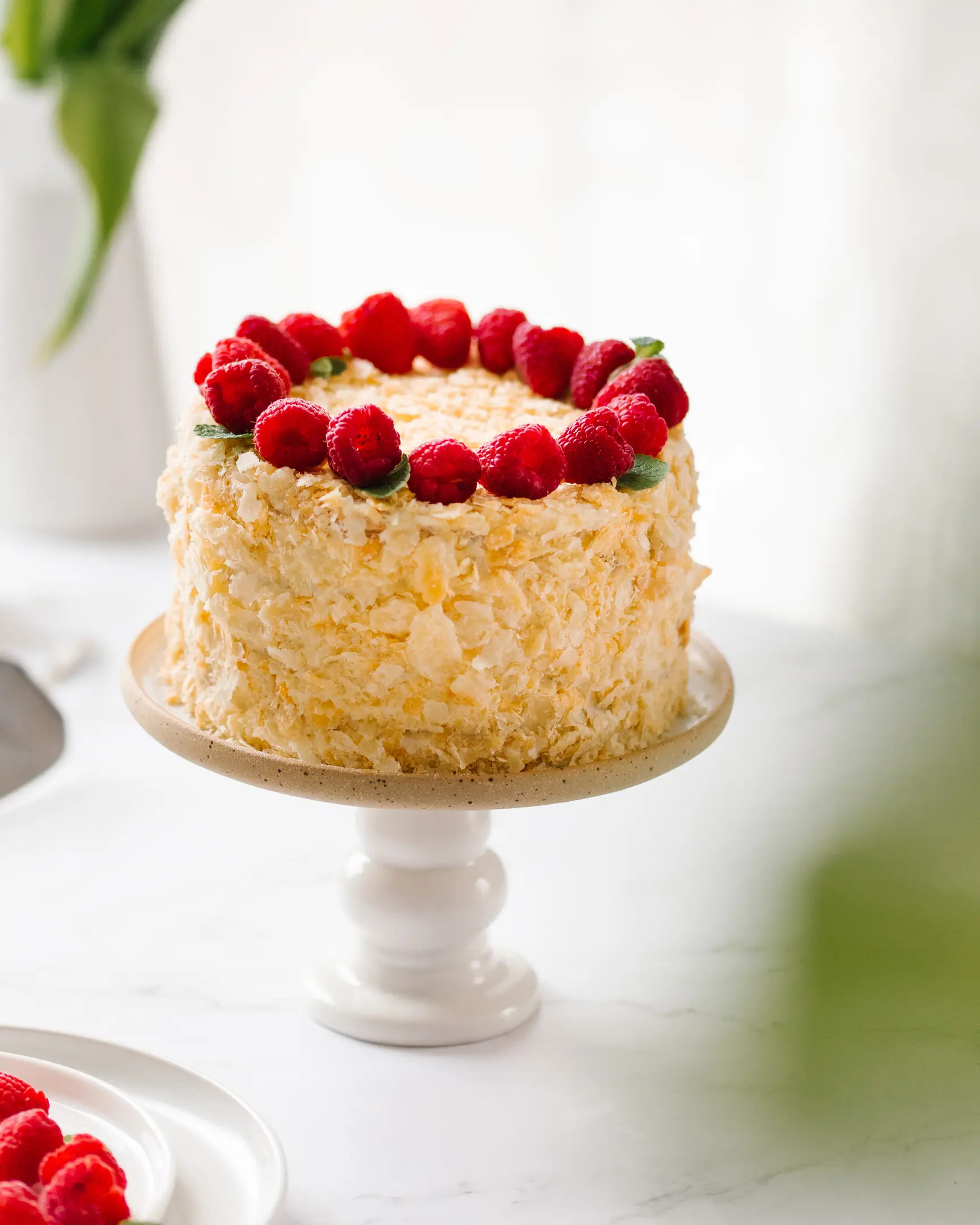 Многопластова торта, 16 см, със златиста ронлива поръска и пресни малини на поставка. Рецепта за 8 души.