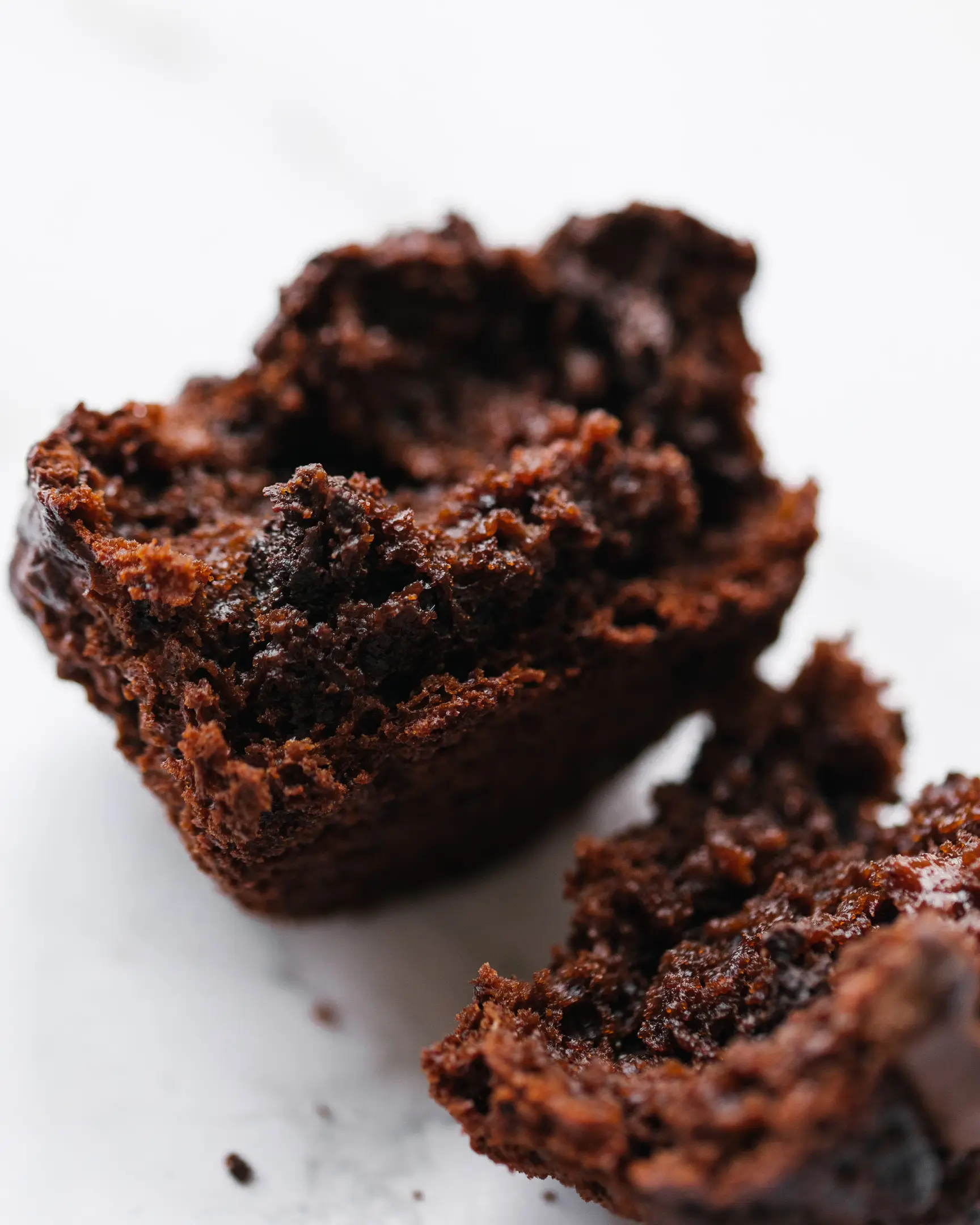 Delicious, moist chocolate-apple cupcake, cut open to reveal rich texture and melted chocolate pieces.