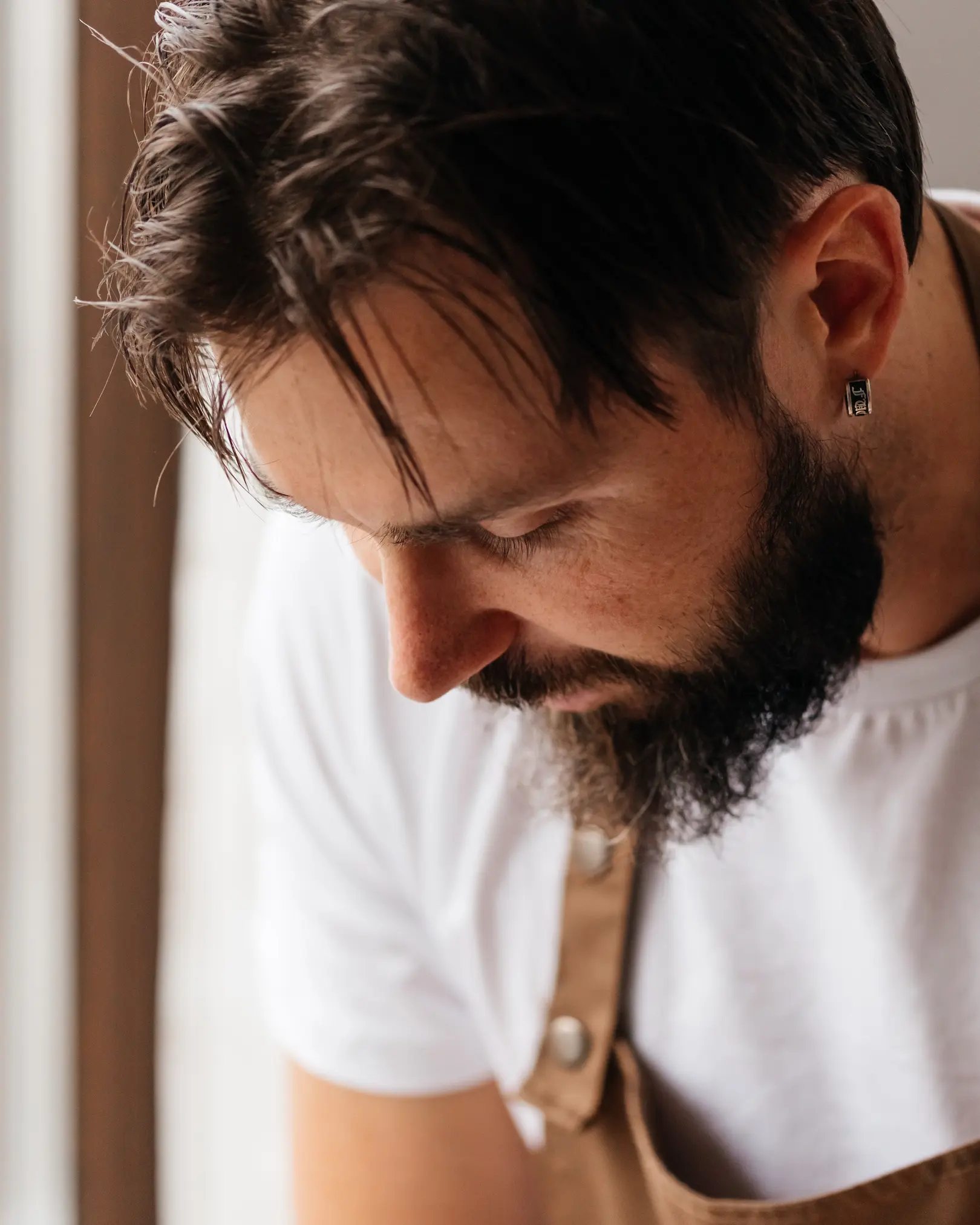 Съпругът пицар, съсредоточен върху омесването на домашно тесто за пица с брашно 00.