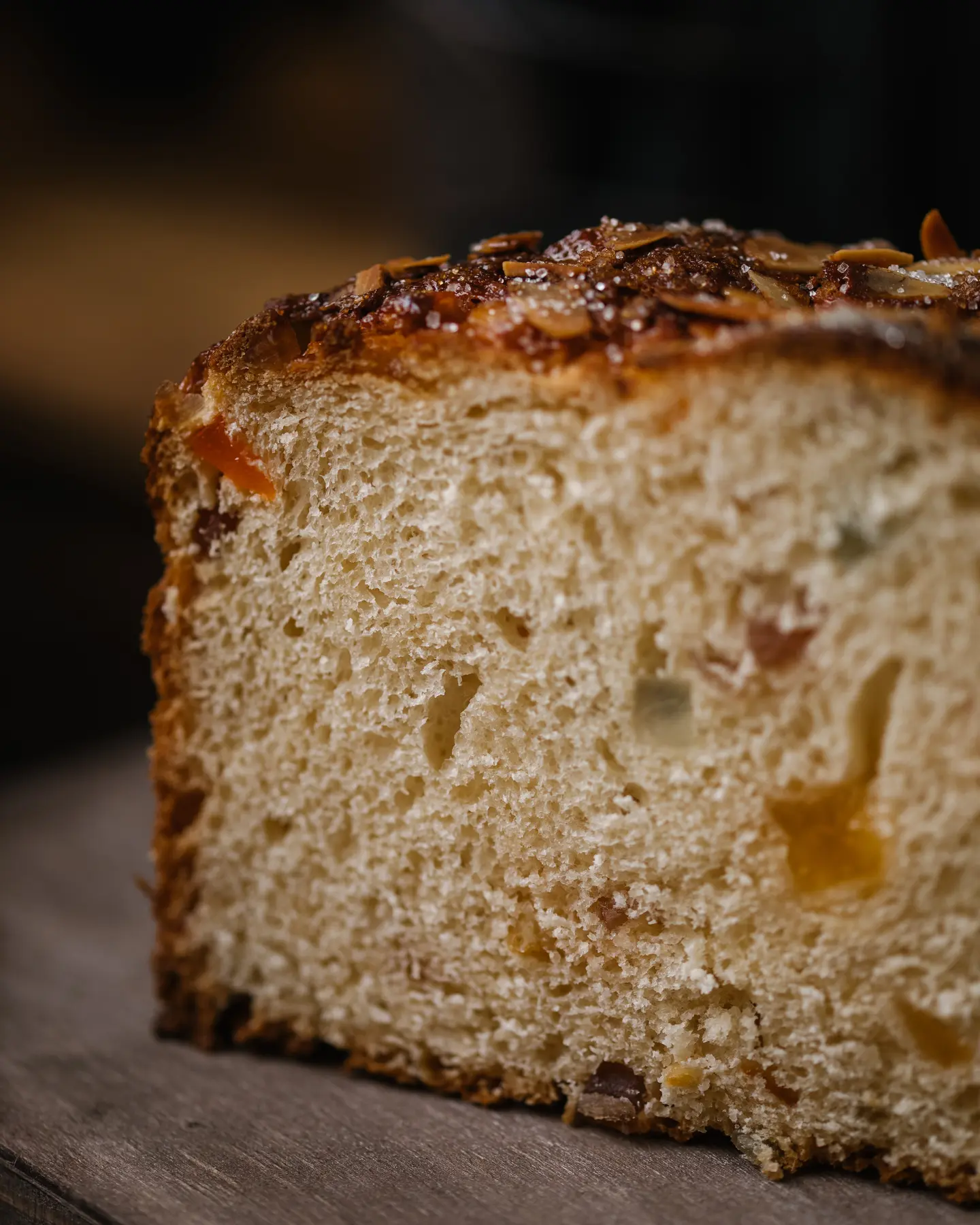 Bulgarian kozunak slice with candied fruits & crumble, on a wooden board, decorated with quail eggs.