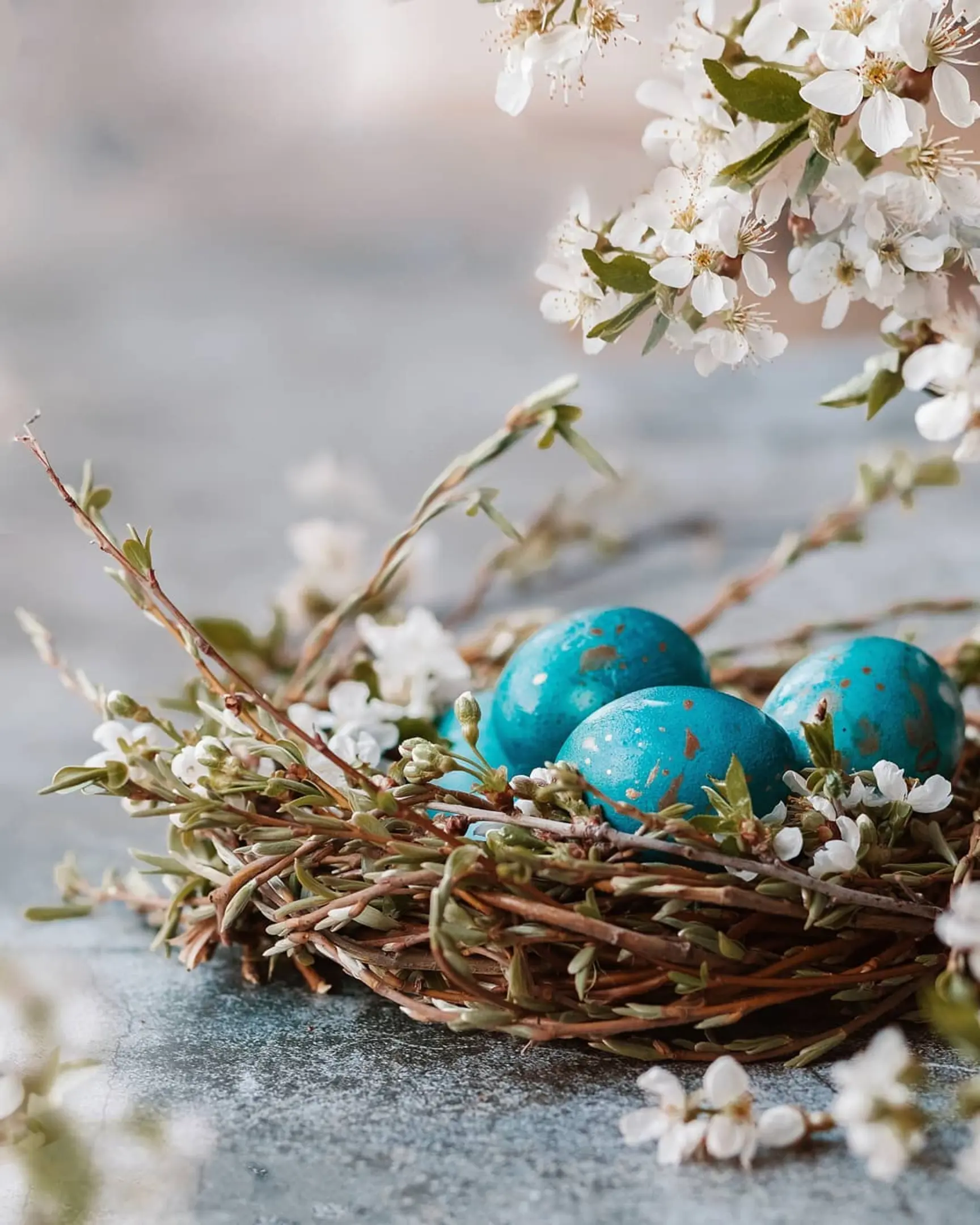 Blue, gold-speckled Dragon eggs in a nest with white blossoms, created using red cabbage dye.
