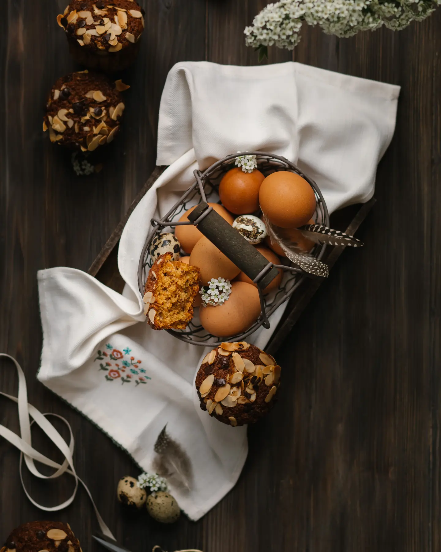 Moist Banana Carrot Muffins with almond petals & chocolate chips, alongside fresh eggs in a basket.