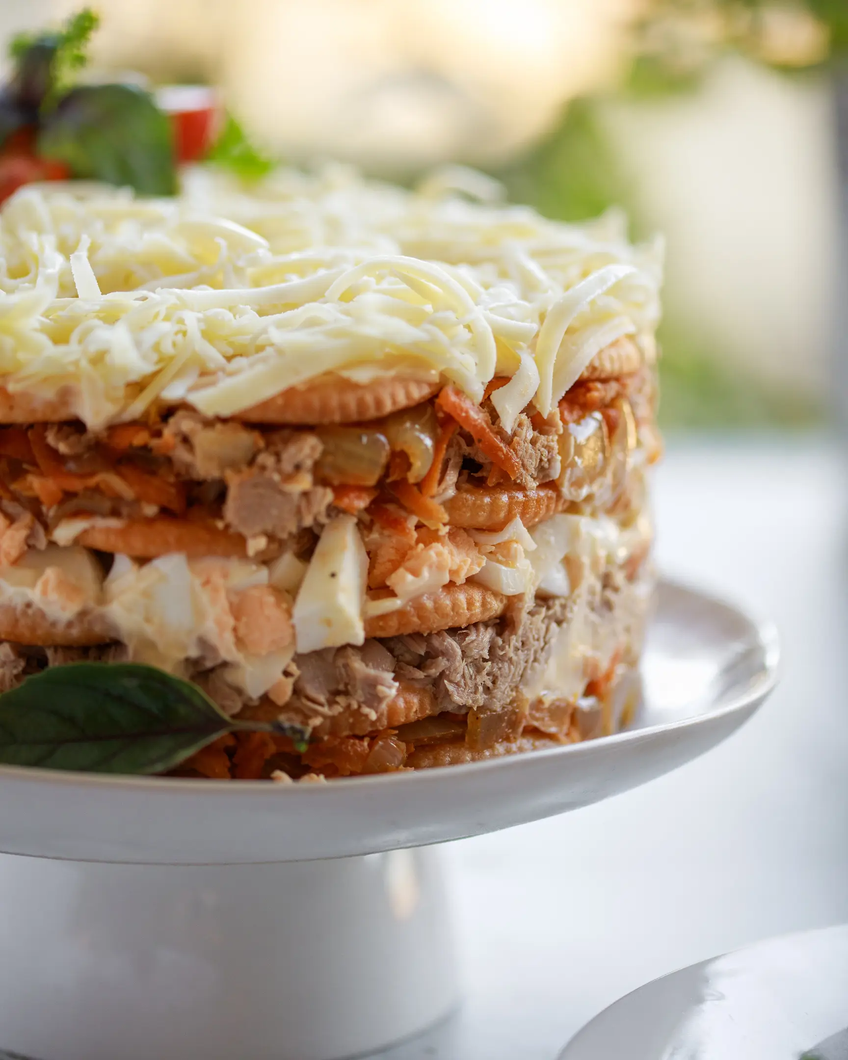 Слоеста солена торта с риба тон, крекери, яйца, задушени лук и моркови, настърган кашкавал, за Нова година.