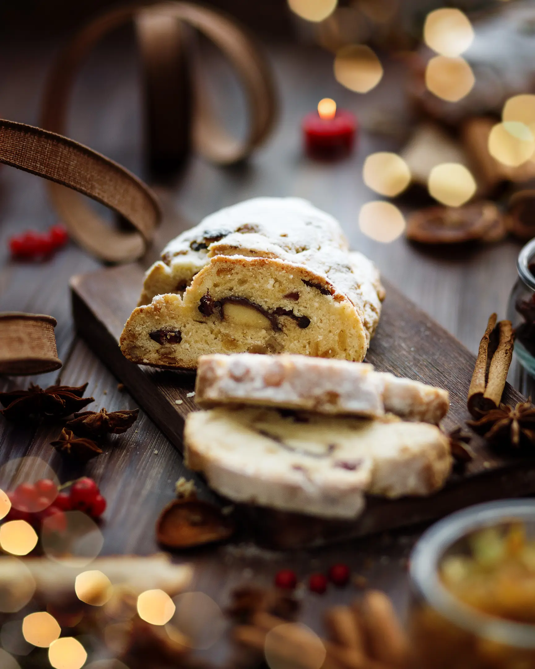 Нарязан домашен коледен щолен с кандирани плодове и марципан, поръсен с пудра захар, празнично лакомство.