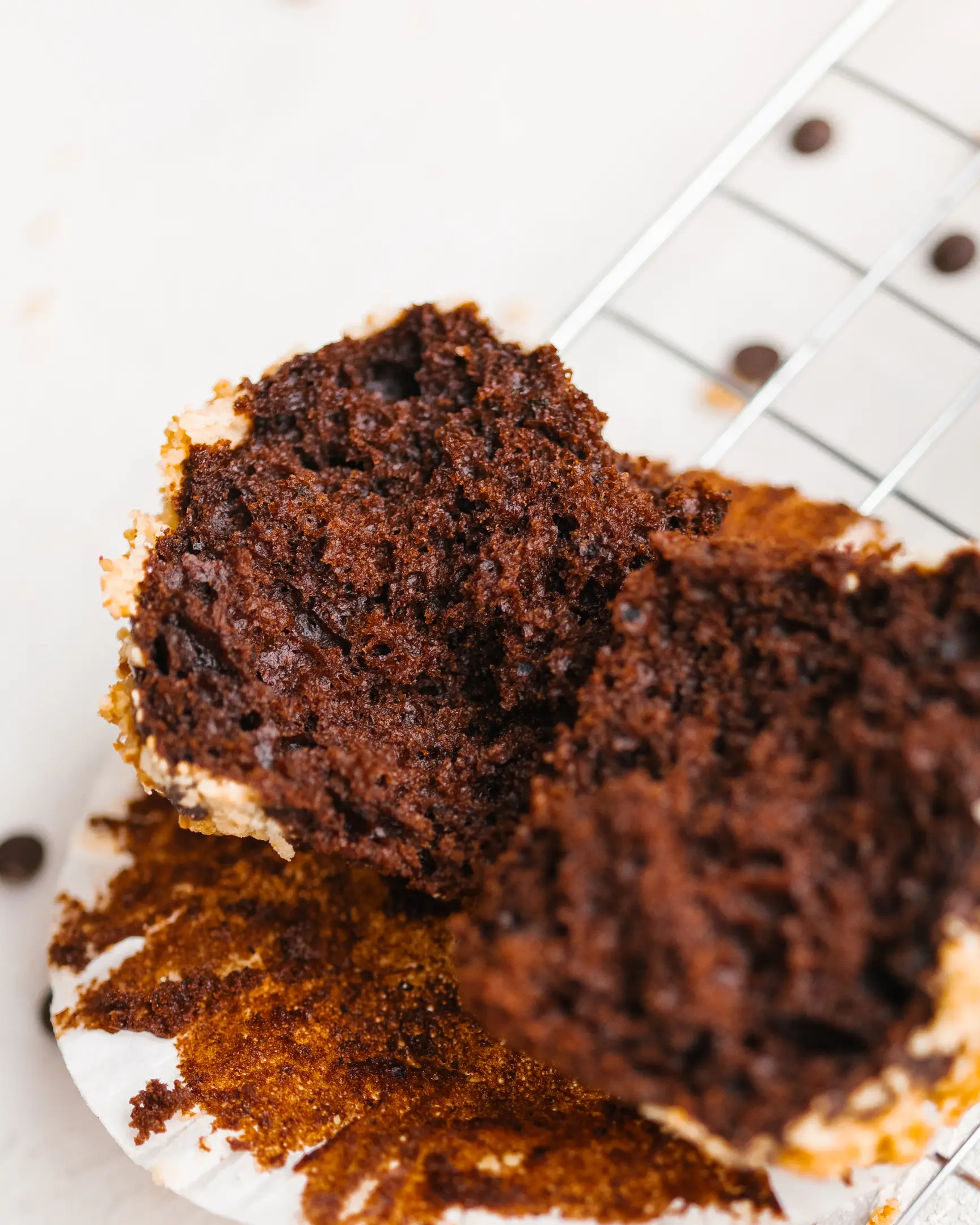 Cut pumpkin chocolate cupcake showing its moist, dark interior and crumble. A delicious baked pumpkin puree recipe.