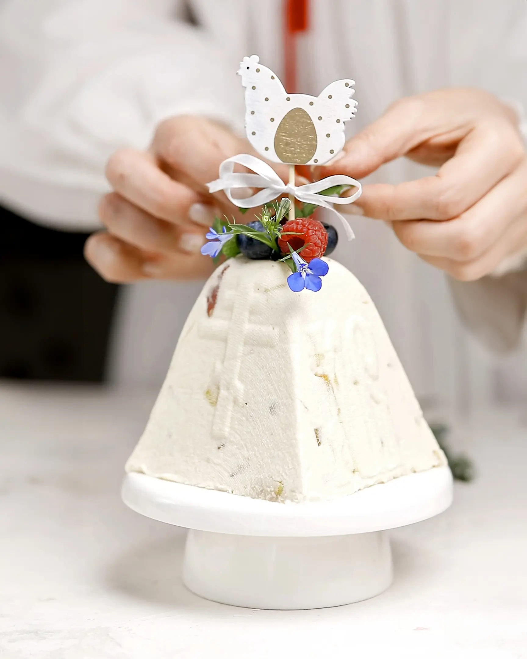 Декориране на традиционен Великденски десерт с извара, с пресни плодове и Великденска кокошка.