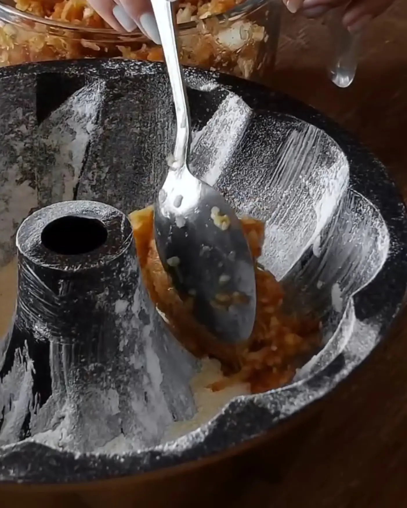 Layering grated apples into a greased, floured bundt pan for a wholesome Lazy Layered Pie.