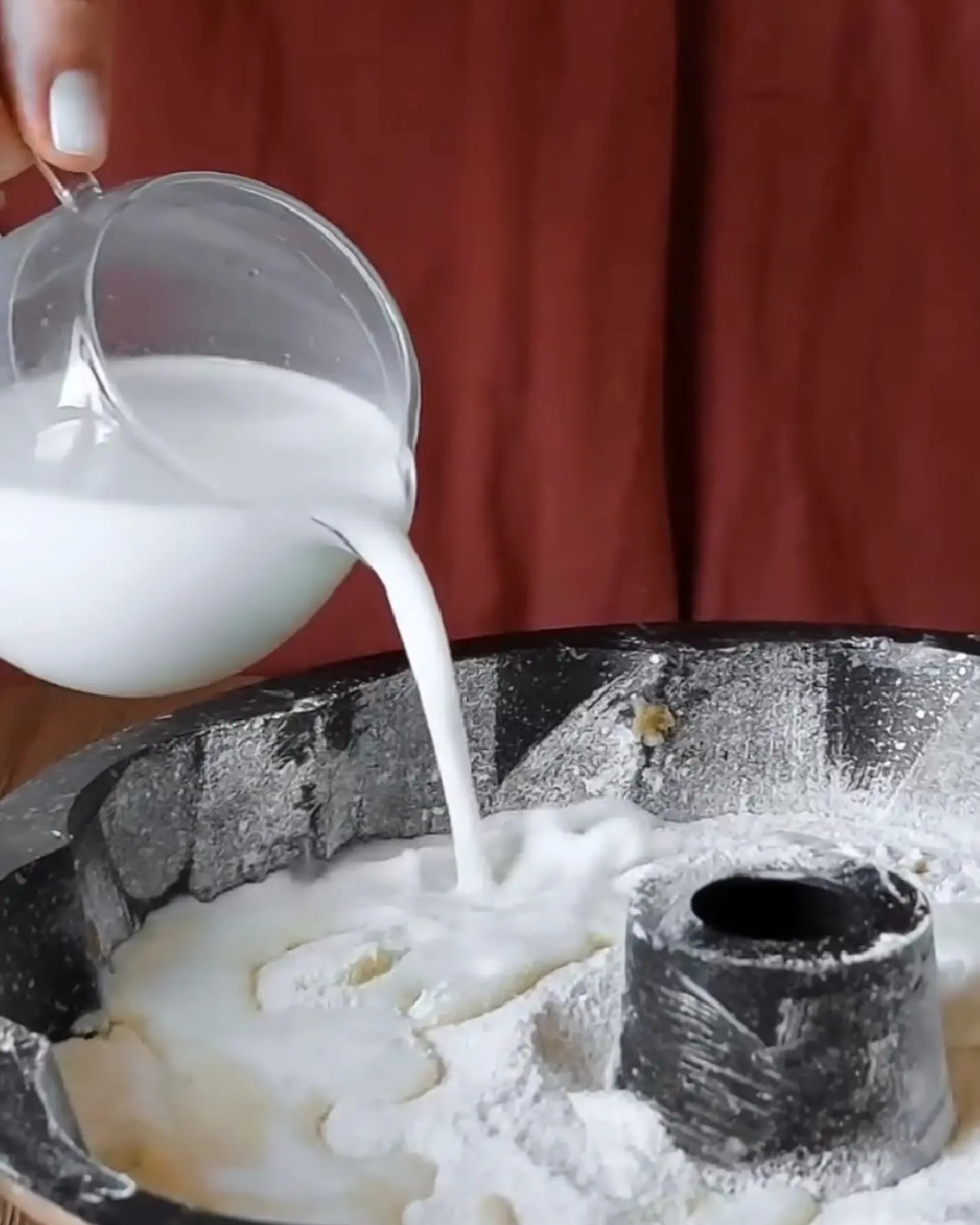 Pouring cream and melted butter over the layered semolina apple mixture for the Lazy Layered Pie.