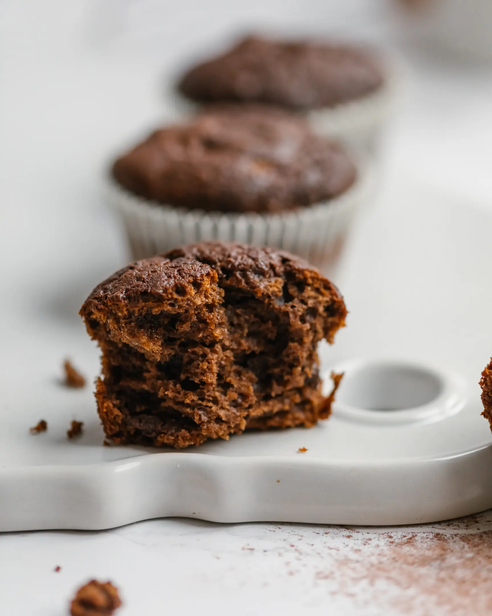 Moist, healthy chocolate cupcake (no flour, no sugar) on a white board. Rich in magnesium for PMS relief.