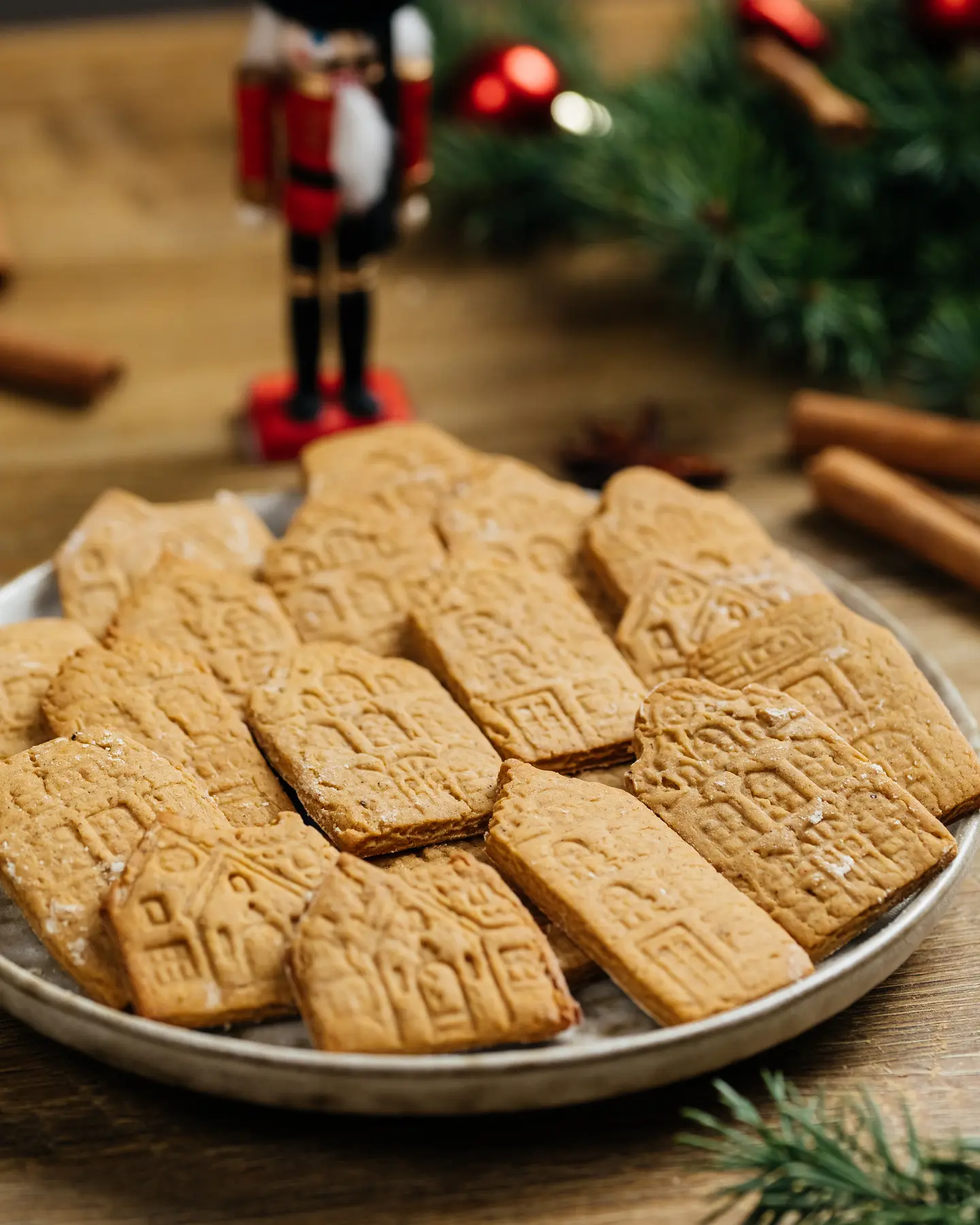 Rustic rye honey cookies with intricate European house designs; festive holiday decor.