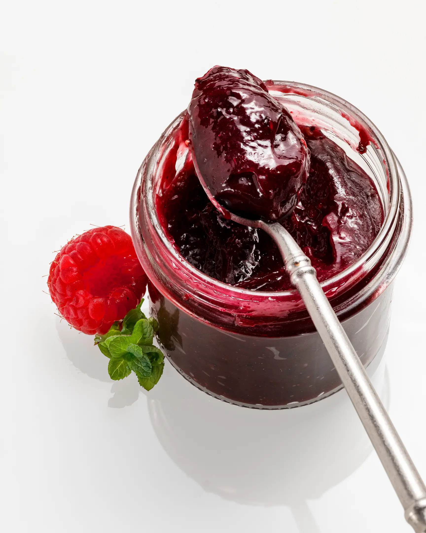 Буркан домашен горски карамел с лъжица, прясна малина и мента. Идеален за гурме торти и тост.