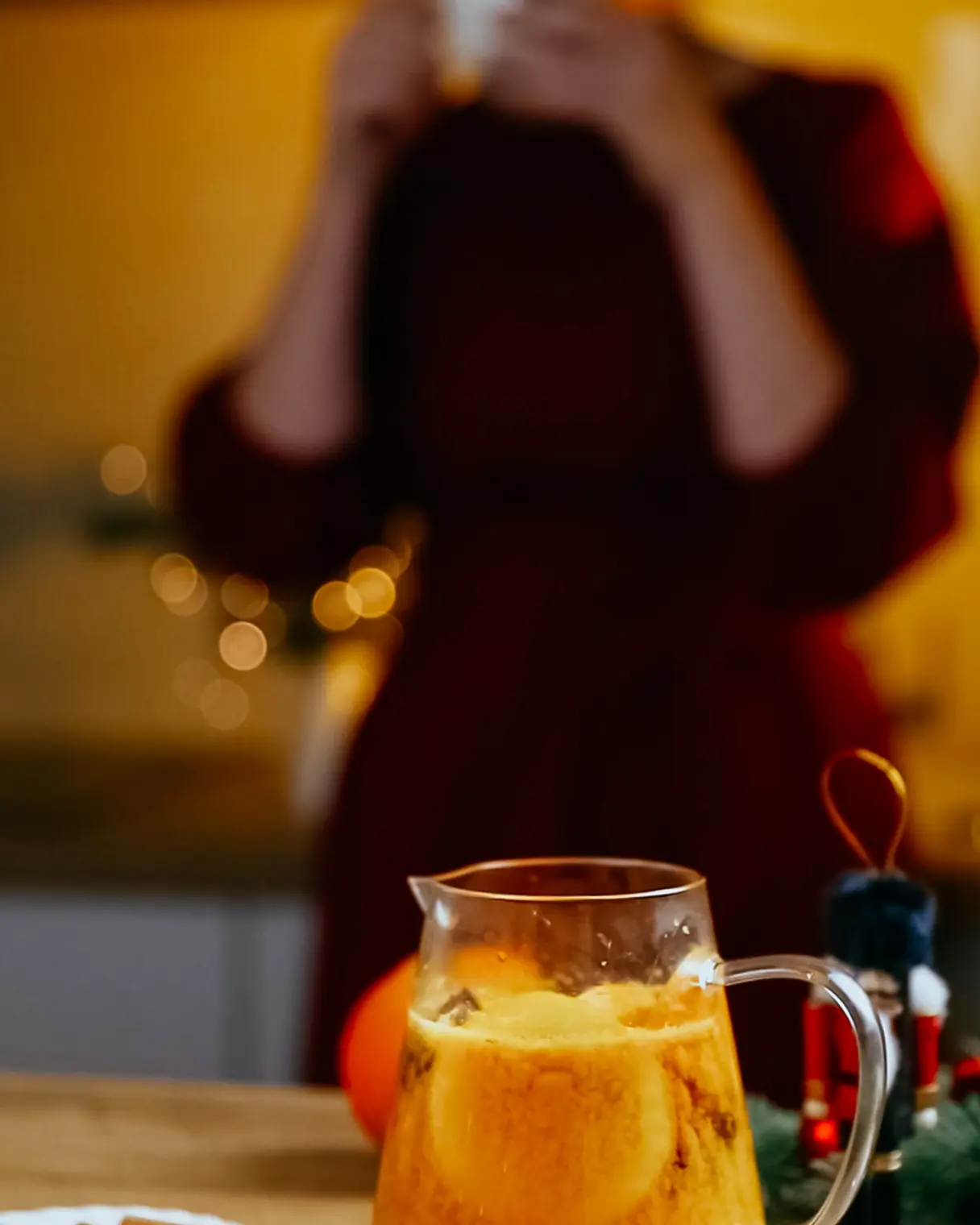 Cozy sea buckthorn tea with orange slices, cinnamon, & spices in a pitcher, perfect for a warm evening.