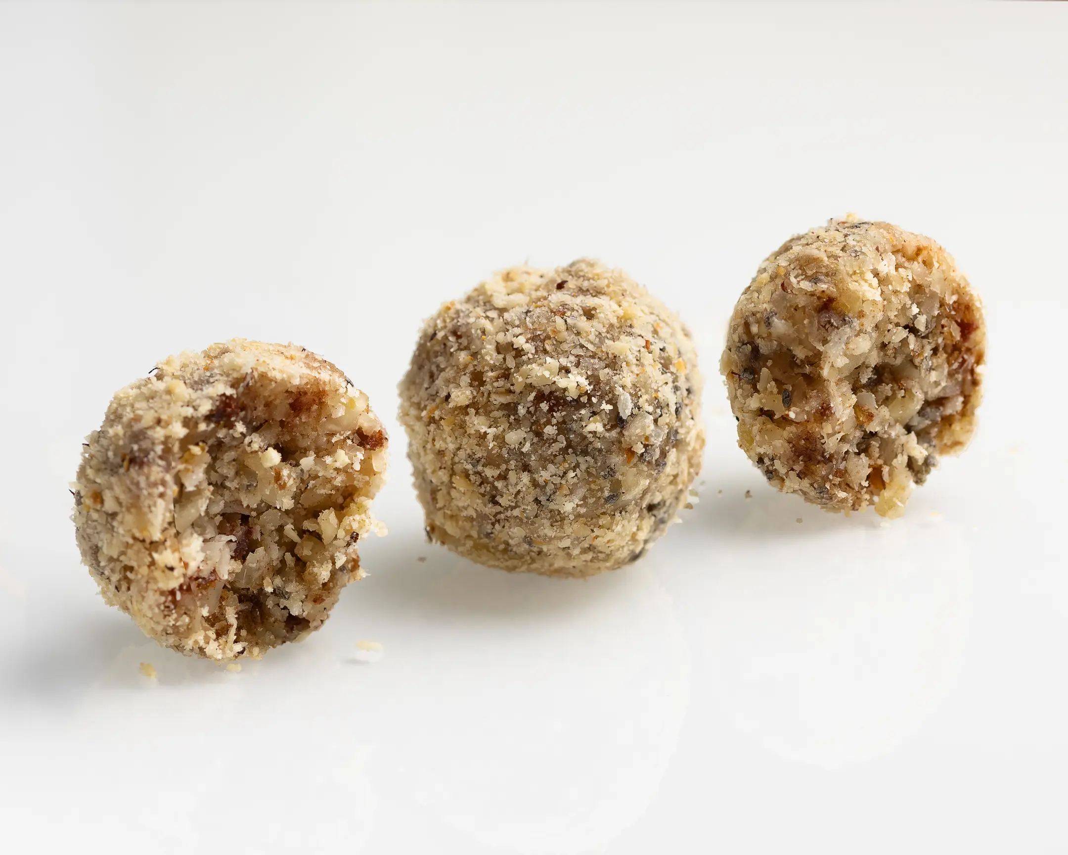 Three healthy Almond-Apricot Candies, coated in nut flour, offering natural, no-sugar energy and nutrients.