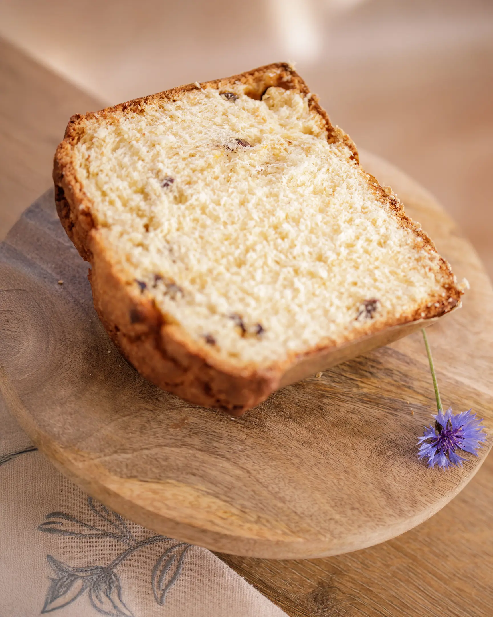 Slice of kulich bread with candied fruit, showcasing moist & rich crumb from optimal butter and salt addition.